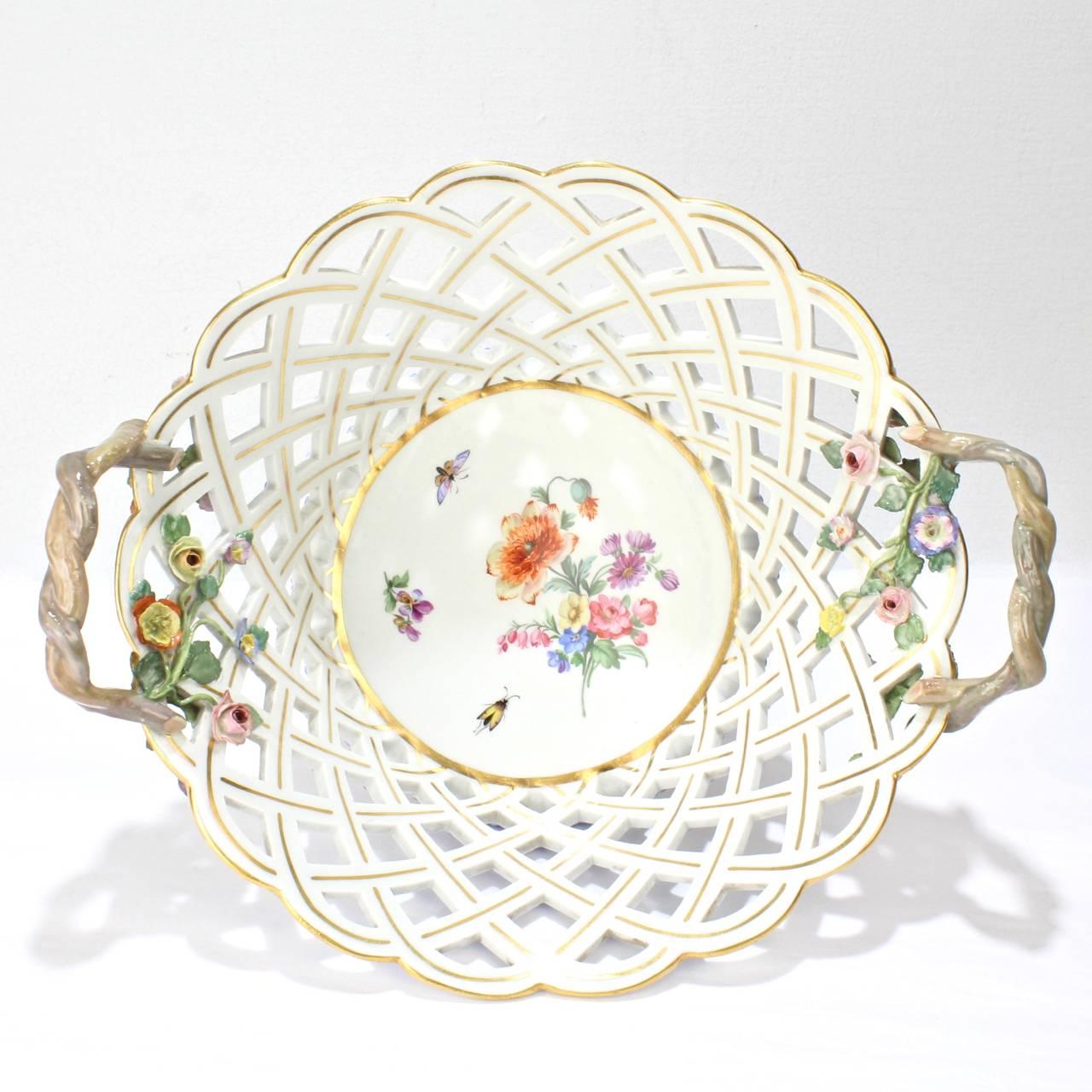 A fine, antique Meissen porcelain basket with openwork, twig handles, and flower encrusted vines, and enamel Deutsche Blumen decoration. A rare form!

Base marked with a blue underglaze crossed swords factory mark, an incised 62, and an impressed