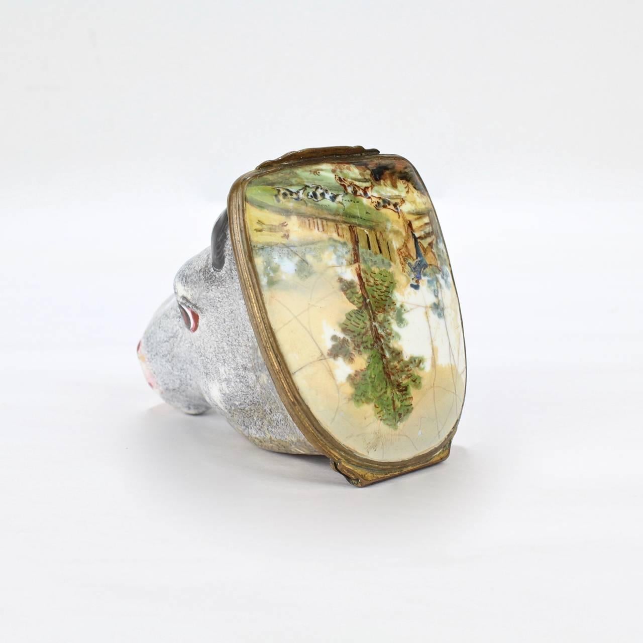 A fine and very rare, figural horse head Battersea or South Staffordshire enamel bonbonniere or large snuff box.

A gilt bronze mount connects the lid painted with a bucolic landscape scene.

Measure: Length ca. 3 3/8 inches.




 