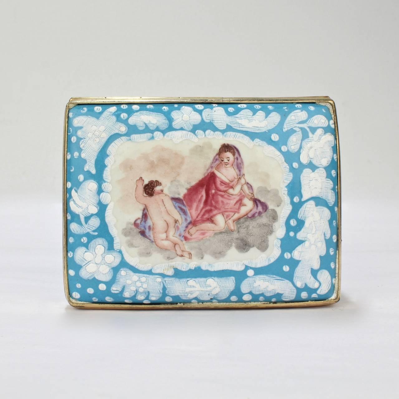 A fine antique English Battersea Bilston table snuff box.

The decoration includes cherubs to the lid and floral sprays to the sides of the boxes exterior. The exterior has a robin's egg blue ground and white highlights. The interior lid depicts a