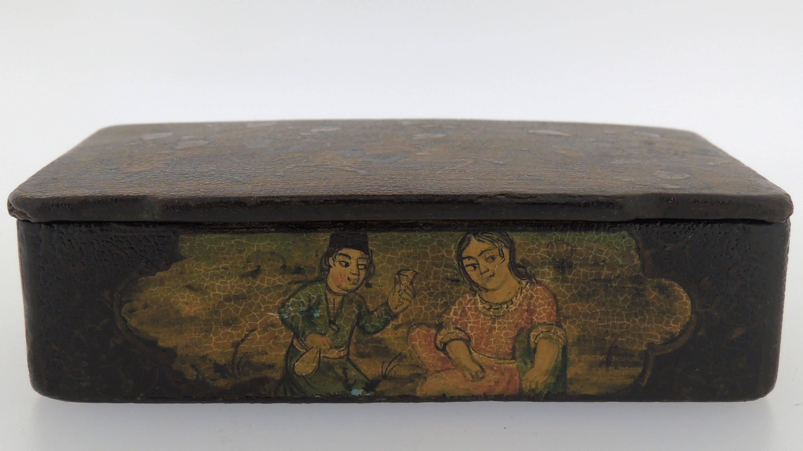 Eine feine antike persische Schnupftabakdose aus Pappmaché.

Bestehend aus einem lackierten Pappmachê mit Verzierung auf dem Deckel und allen 4 Seiten. 

Auf dem Deckel der Schachtel sind zahlreiche Männer auf Pferden abgebildet, die Chovgan