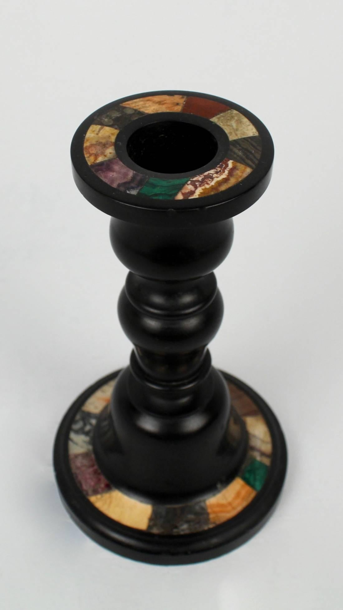 A fine Pietra Dura single candlestick. The baluster form slate body is inlaid with various species of marble and hard stone on both the base and the candle cup top.

Height: circa 5 3/4 in.

Condition: There is minor fritting and small chips the