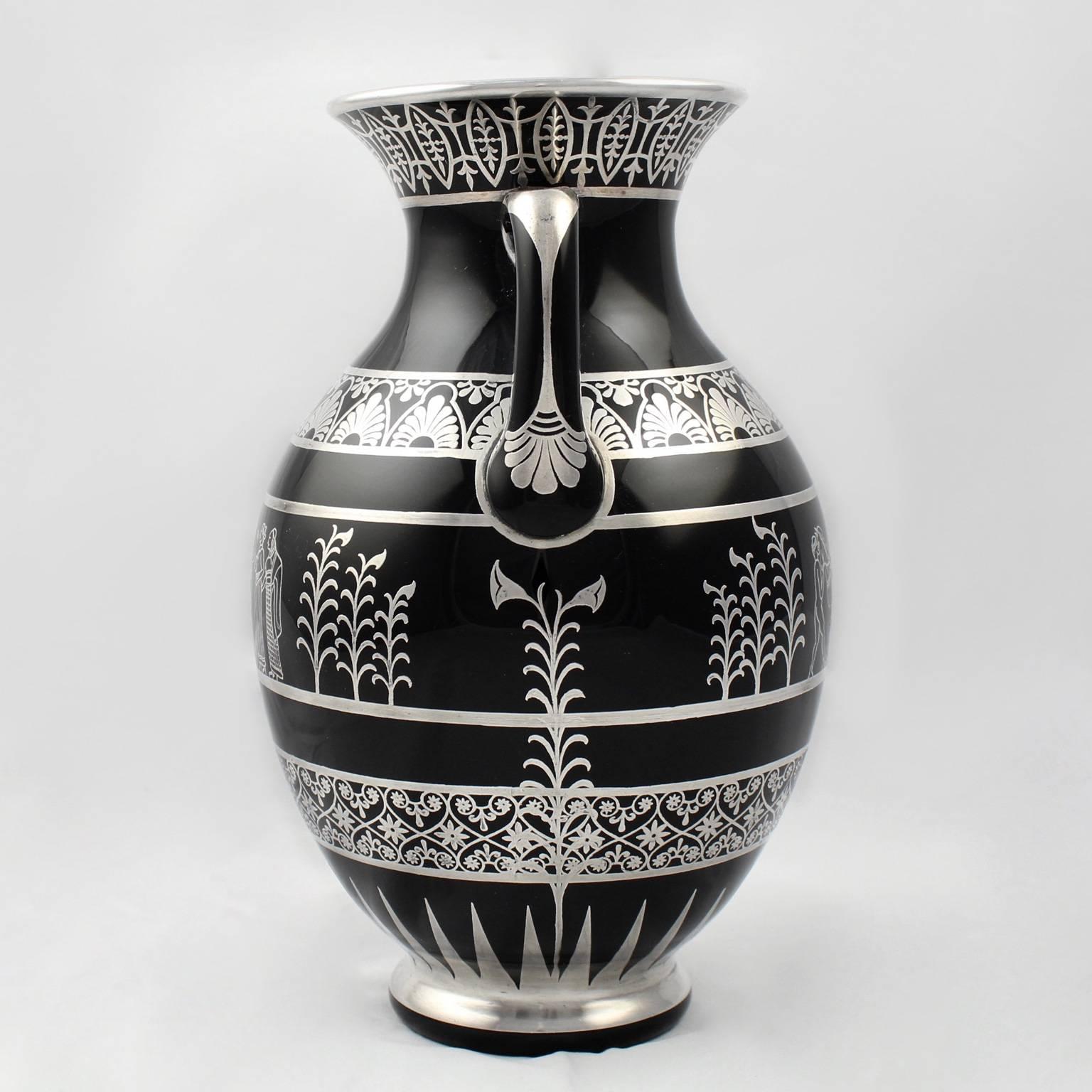 A fine Art Deco period, Greek Revival style black glass silver overlay vase by the Rockwell Silver Company. A terrifically rare form for this early American silver overlay company. 

The central motif depicts two nude males attending a horse and