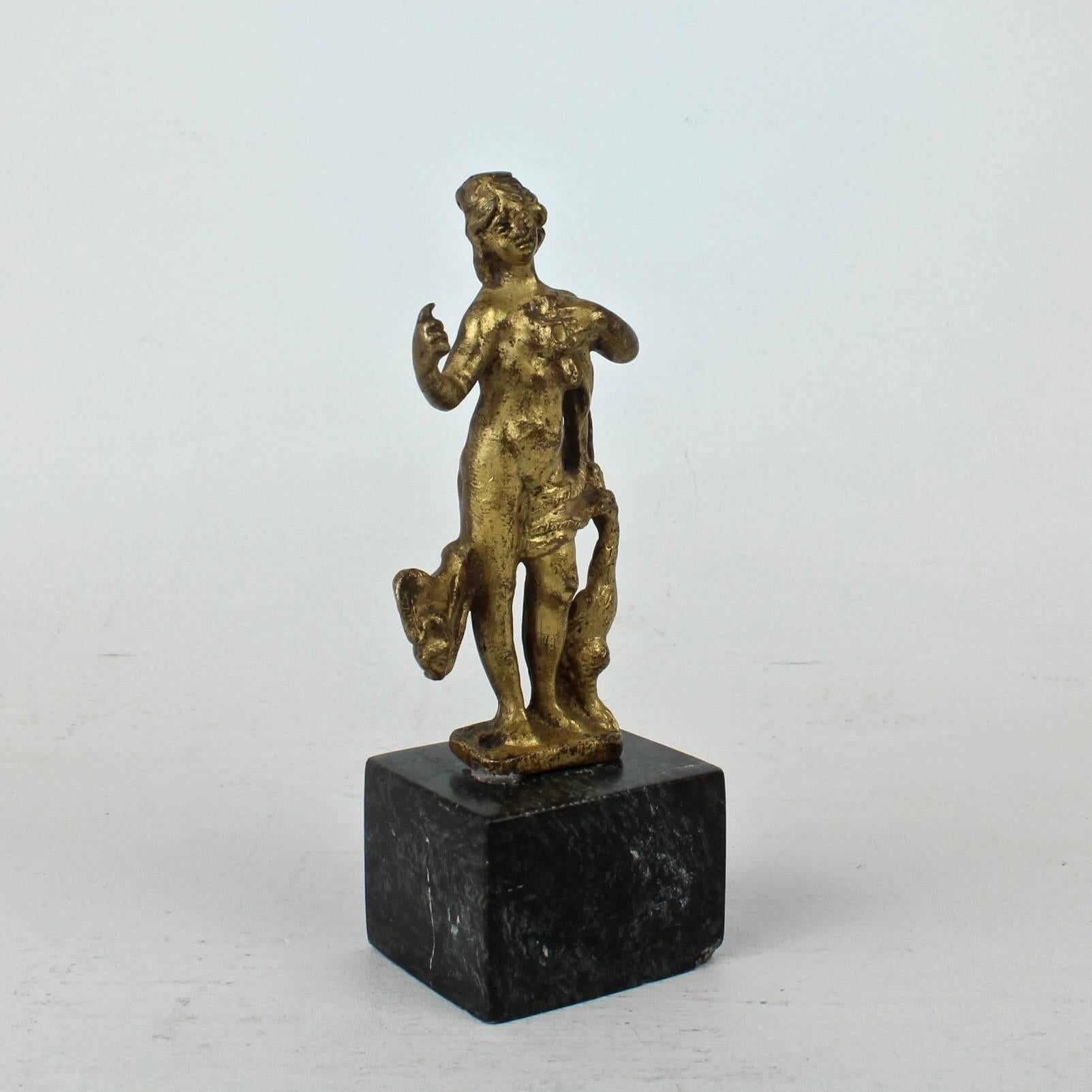 An early gilt bronze statuette. These were often used as a furniture mounts. It is likely Venetian and dates to the 17th century. 

It depicts the Roman Godess Juno semi-clad in drapework with her right hand extended raised and attended by a
