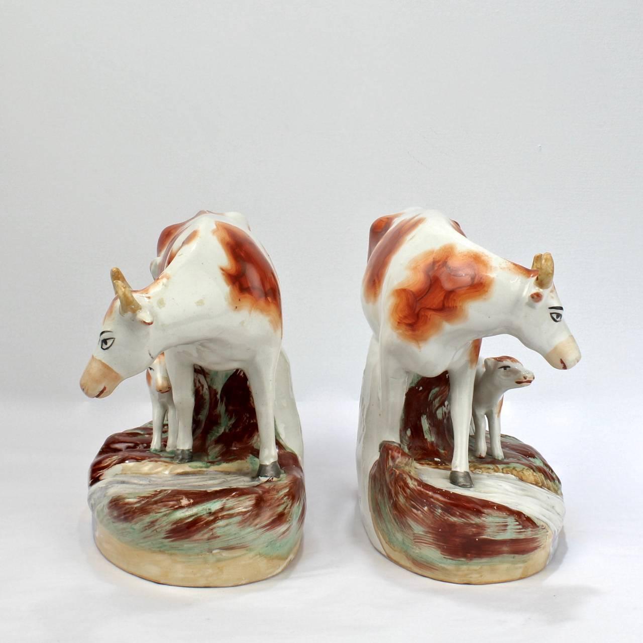 Une belle paire de figurines anciennes en poterie anglaise Staffordshire.

Chacune des paires complémentaires représente une vache avec son veau au bord d'un ruisseau.

Avec une légère usure de la peinture.

Longueur du plus grand : environ 10