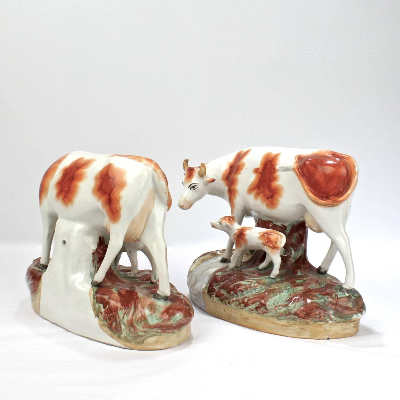 XIXe siècle Paire assortie de figurines en poterie de Staffordshire du 19ème siècle en forme de vache et de veau