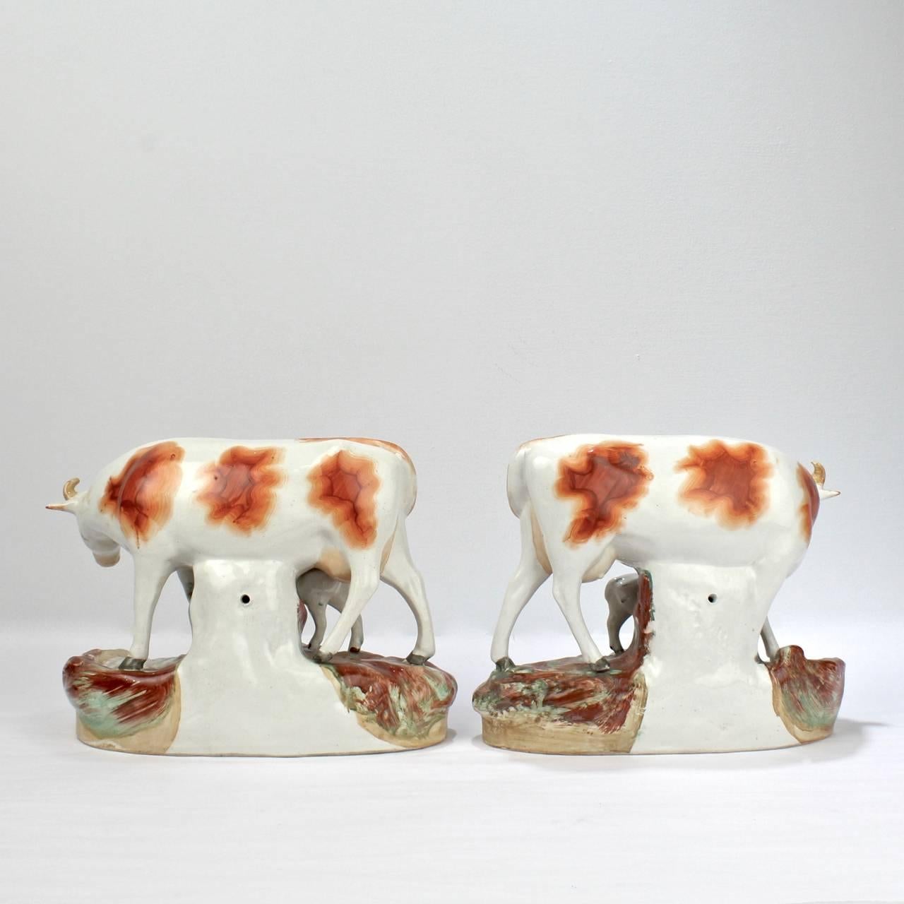 Anglais Paire assortie de figurines en poterie de Staffordshire du 19ème siècle en forme de vache et de veau