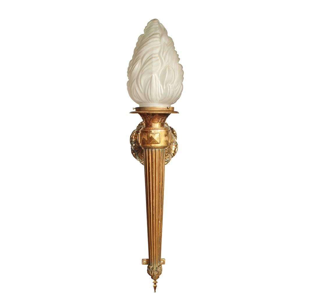 This classically inspired brass sconce with its fluted shaft and decorative scrollwork dates to the late 19th century. Its generous 42” length adds a dimension of drama to an already statement making fixture. The torch form is made complete with a