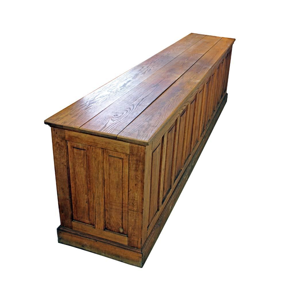 This extra long counter was manufactured in the 1930s and was made for getting the job done. Crafted from solid oak, the handsomely paneled front is as comely as the myriad drawers and cubbies on the reverse. Use it as a desk, a retail counter, a