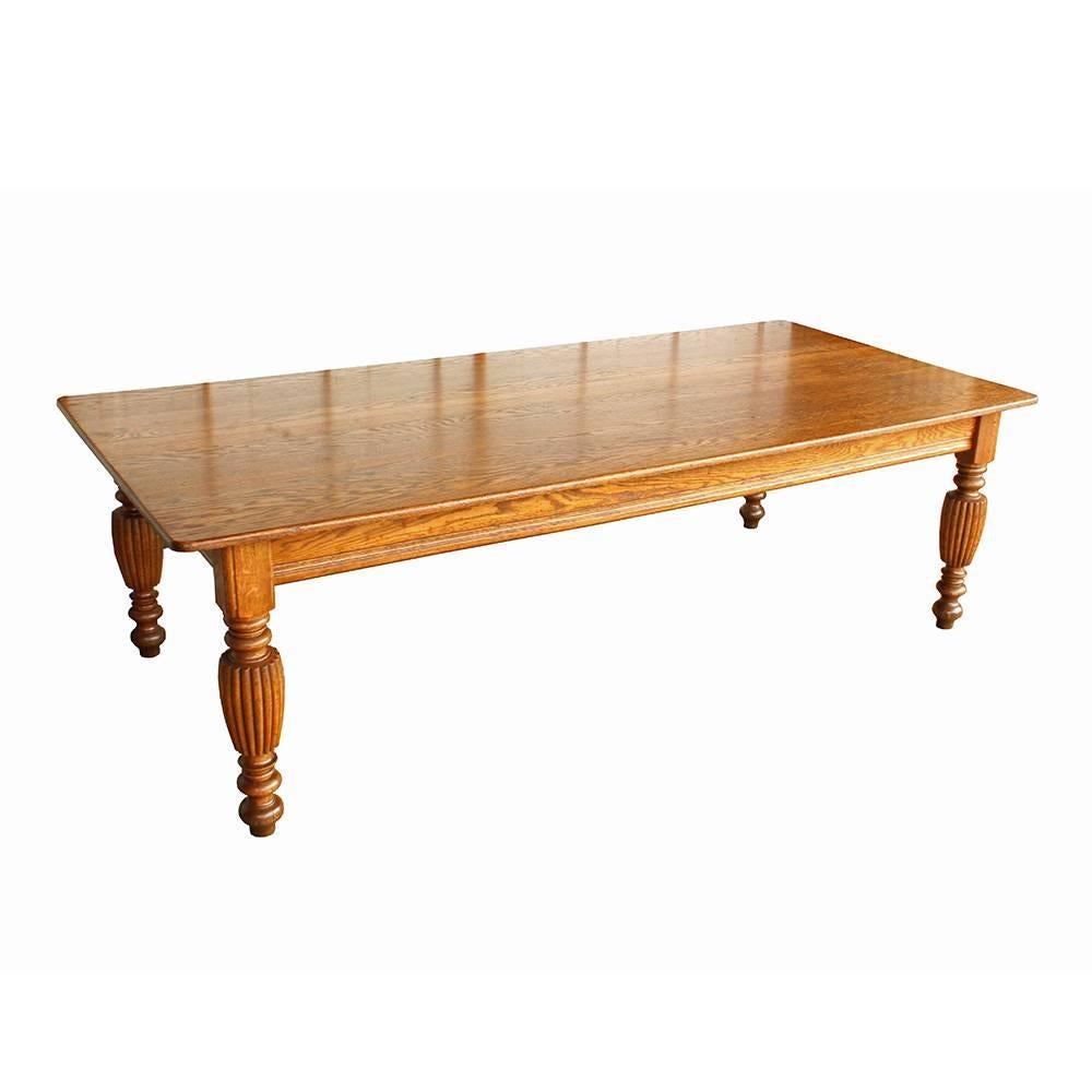 Beautiful patina and magnificent proportions, this gorgeous early 20th century table has elegant details. The fluted urn shaped legs gracefully support the 8’ tabletop, all crafted from warm hued solid oak.