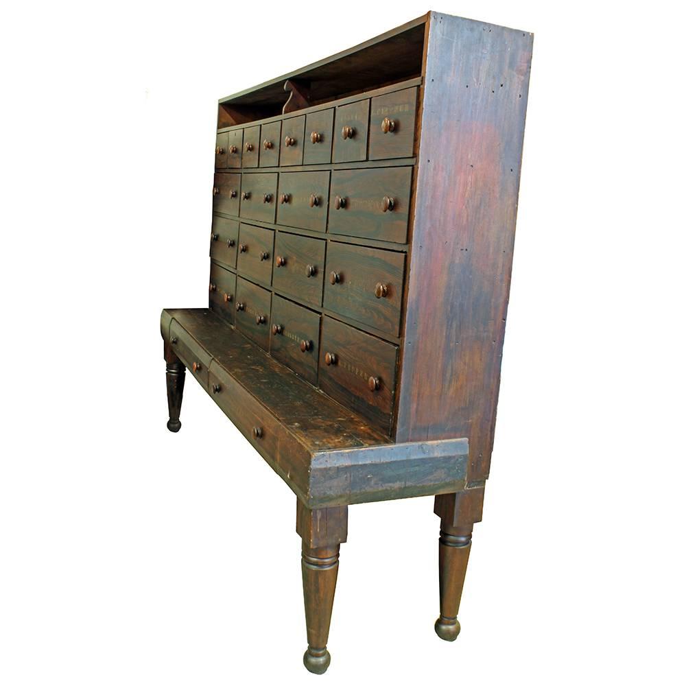 An absolutely exceptional piece of early American furniture. This circa 1850 cabinet is generously sized and has 22 drawers overall. The hand-stenciled drawer fronts are labeled for dry goods, spices, and other sundry items including an obscure