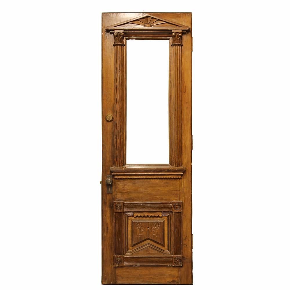 These Victorian era front doors are absolutely beautiful. Executed in an architectural style, each window is surrounded by two Corinthian topped pilasters and a pediment. The dado of each door features four bulls-eye corner blocks, with an in-carved