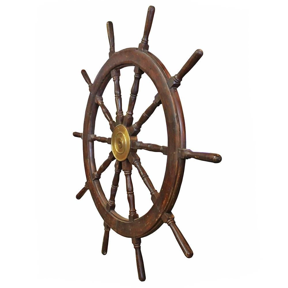 Solid hardwood ship's wheel with ten spokes and a brass fitting. American made, the spokes of this massive ship's wheel feature turned details making it an impressive accent piece in any setting.