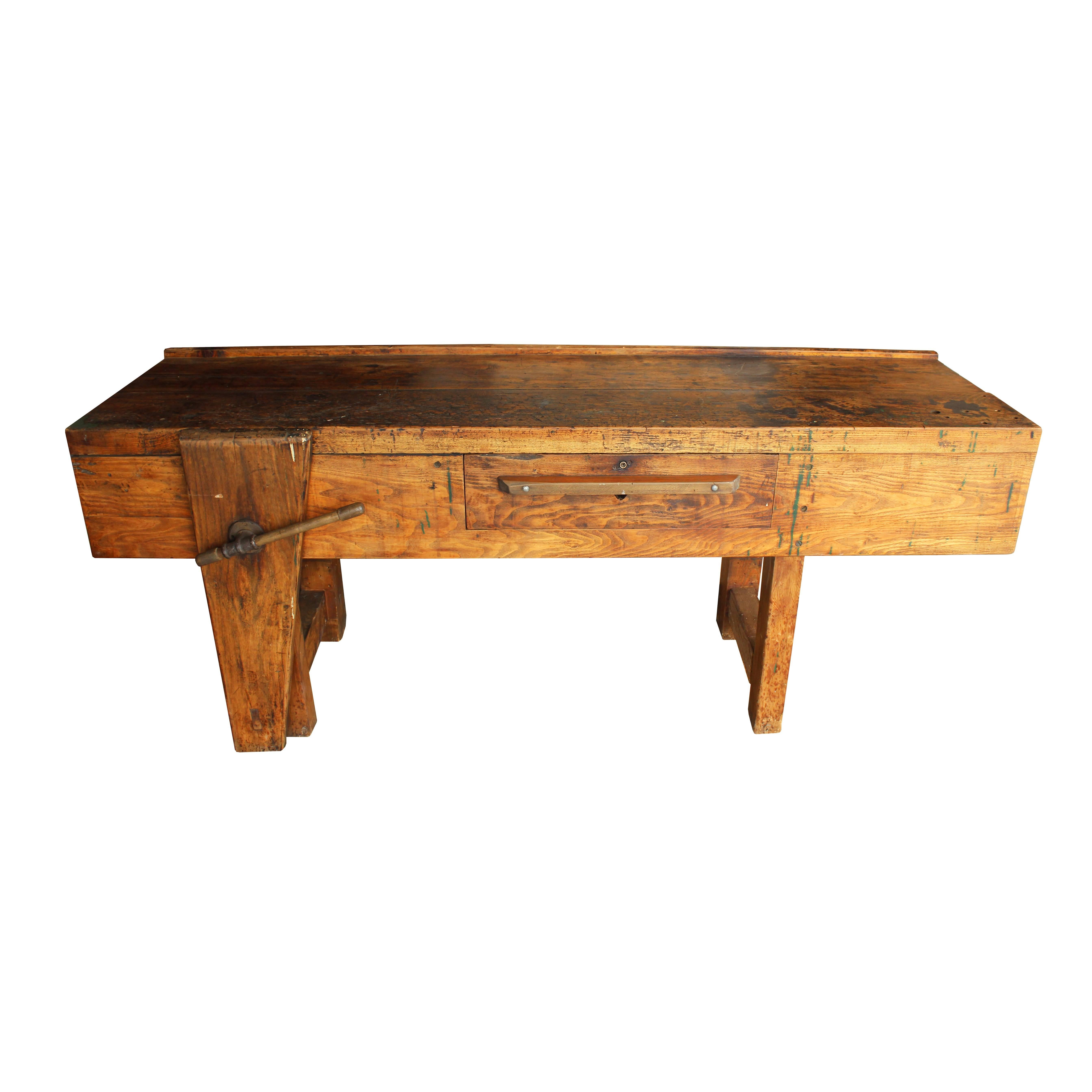 An excellent example of hand-craftsmanship, this simple and solid work bench has an amazing patina that only age and use can create. An amply sized storage drawer and functioning wooden vise add character and utility.