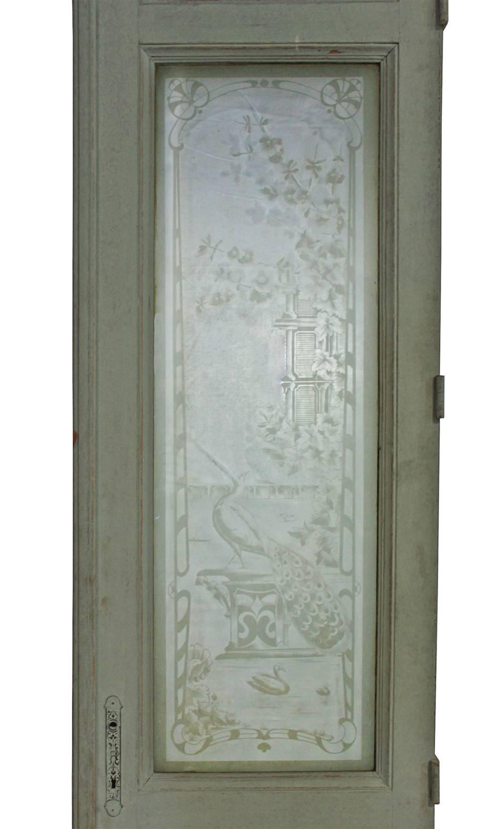 A set of four stunning partition doors in the style of the Aesthetic movement. Each etched glass pane features one of two different scenes of fantasy architecture with birds and vegetation. Each door also has 2 recessed panels and an etched transom