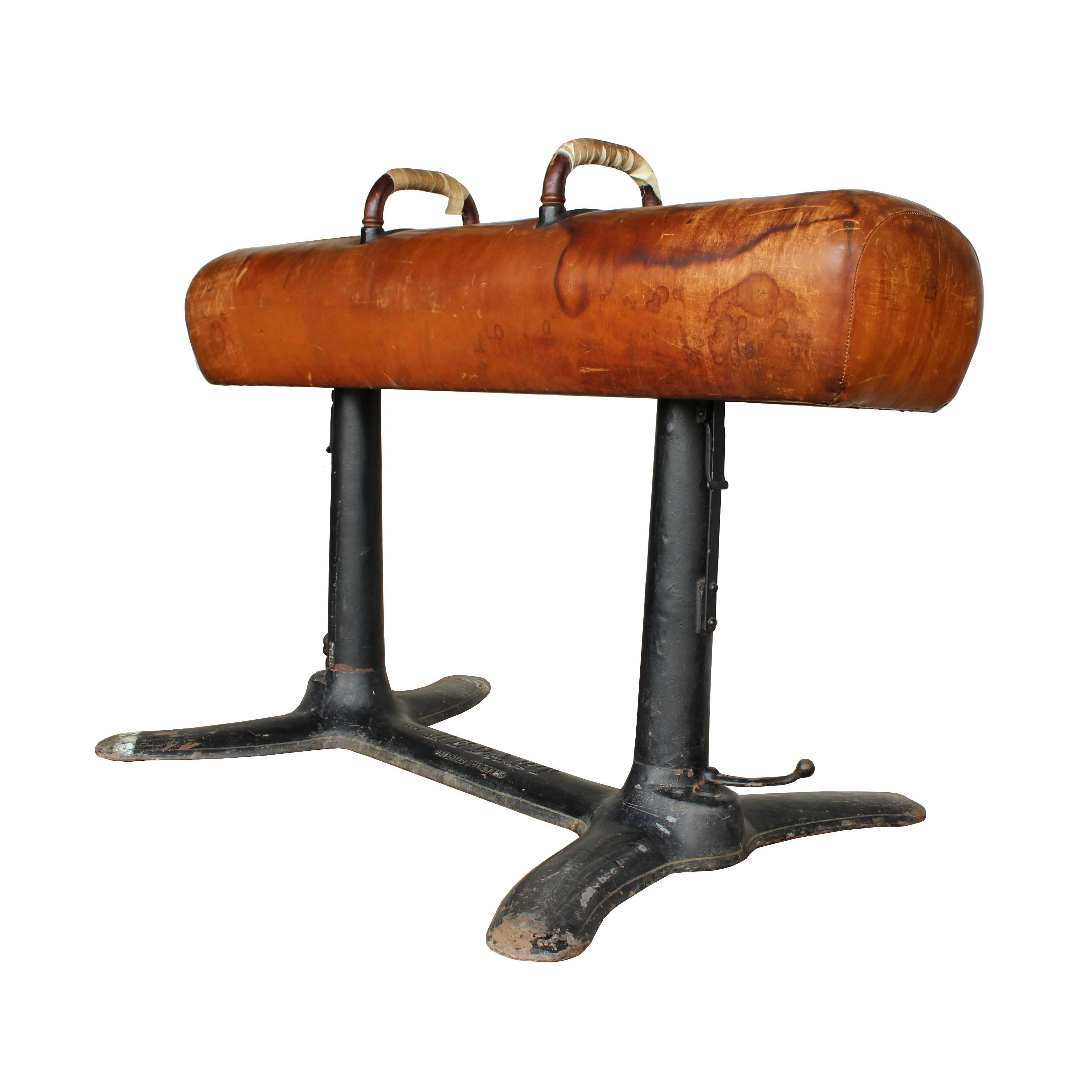 Patented in 1913 with a unique retracting caster system, this Medart adjustable height pommel horse is a one of a kind piece. With leather handles, heavy cast iron base, and a well-aged leather body, this pommel horse would make a statement anywhere.