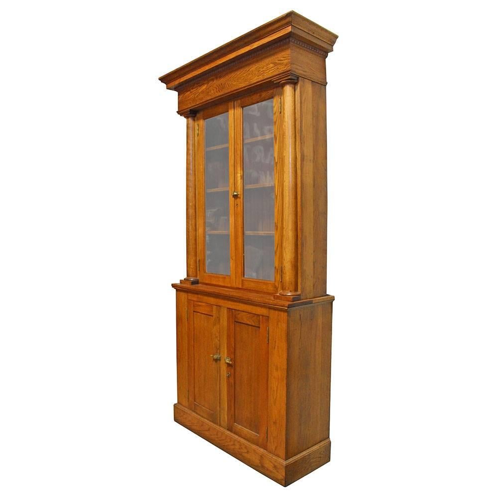 This absolutely dashing late 19th century solid oak liquor cabinet bears a striking resemblance to cabinets produced by the Brunswick Balke Collender Company, though its provenance or makers marks cannot be established. Salvaged from a bar in
