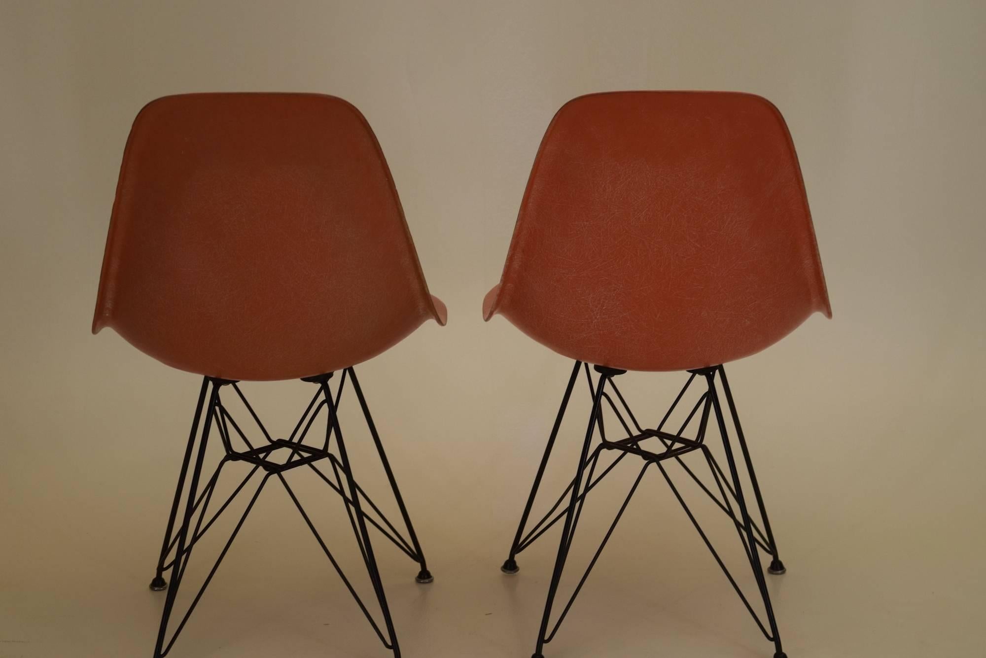 These shell chairs are original fiberglass chairs designed by Eames and produced by Herman Miller, circa 1952.

The color is orange. We have a salmon color chair available within another listing.

The bases are 100% original Eiffel bases dating