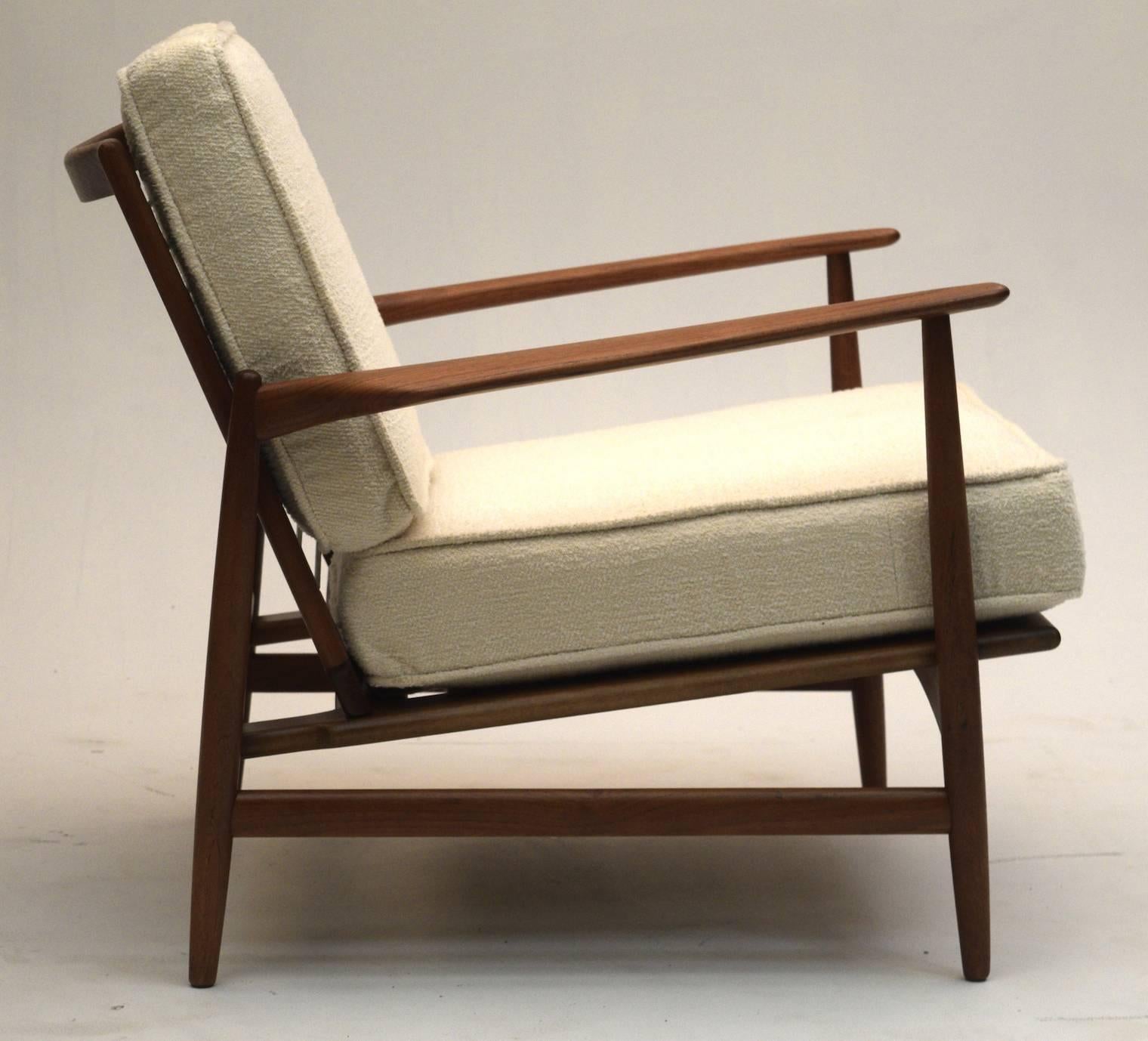 From Ib Kofod Larsen comes this stunning chair in impeccable condition with the teak sealed in a special coating to maintain this look for decades. All new foam, straps and upholstery with a cotton blend in off-white cream coupled with welt cording