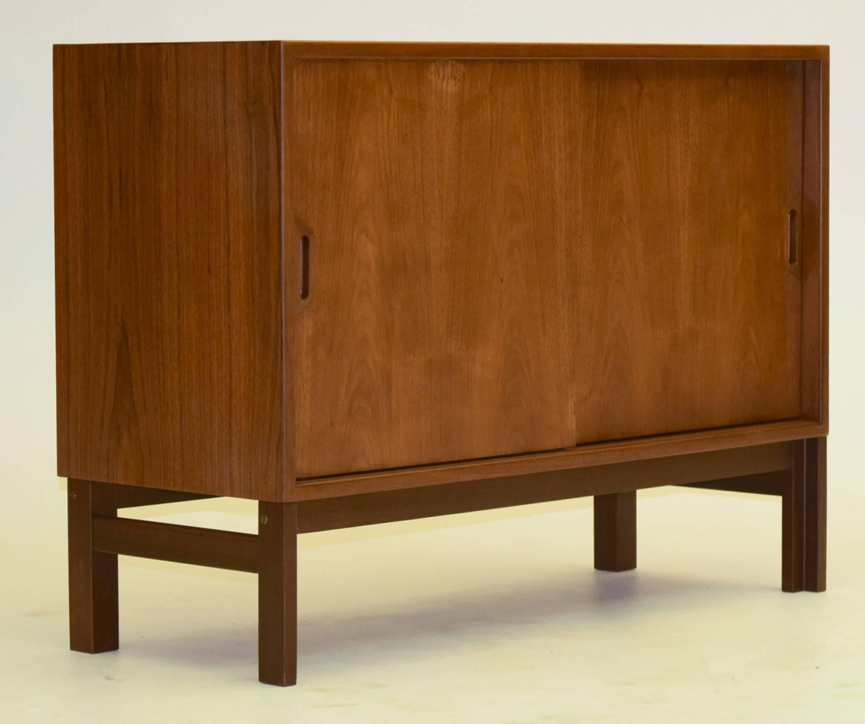 Elegant minimalism and produced from thick lumber and teak, this exquisite sideboard from Denmark (signed) is ideal for smaller spaces being petite but not too much so. Measures 39.25" wide, 15.25" deep and 28.75" tall.

The most