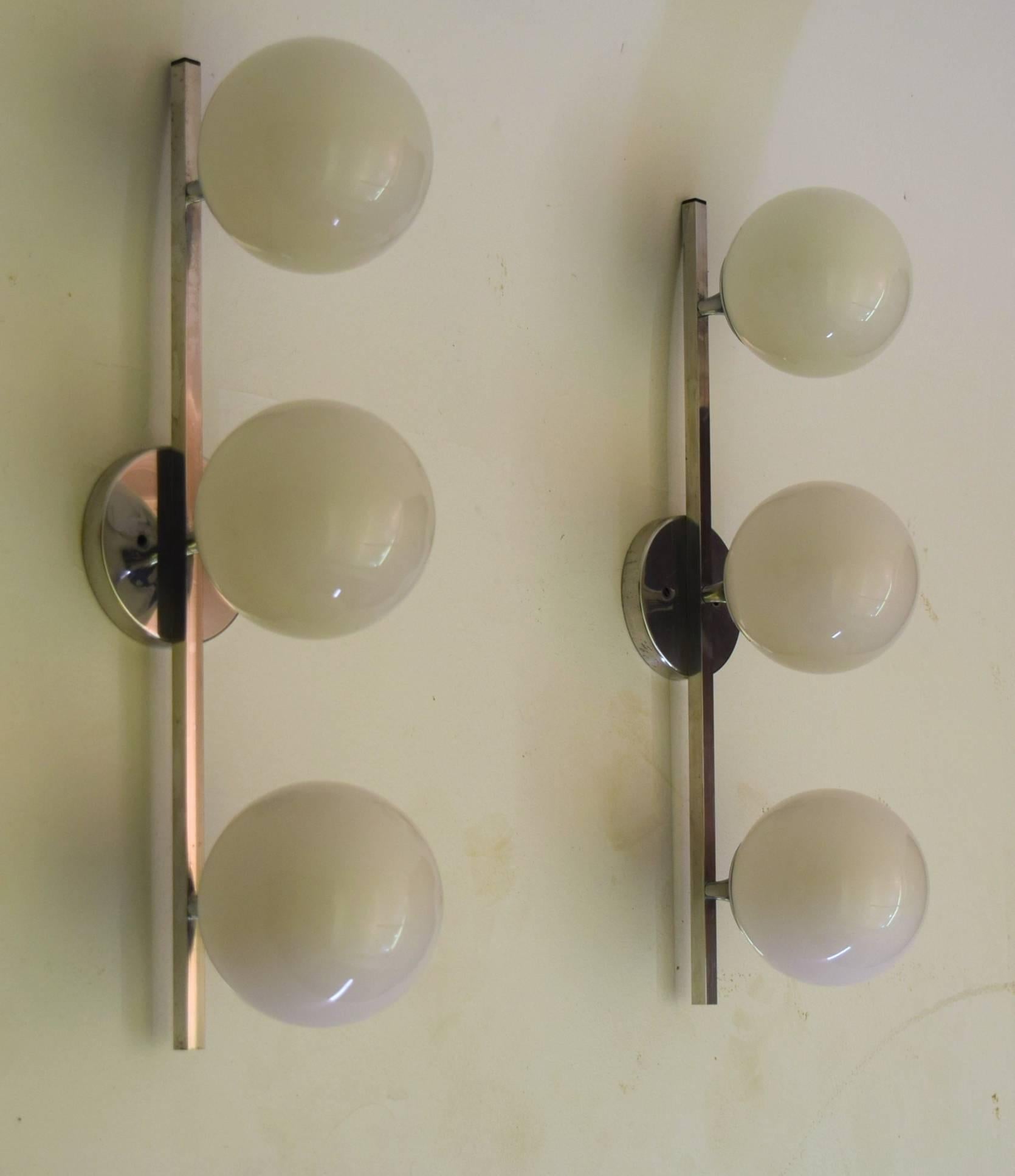 Listing is for both sconces. Each featuring three globes each with 40 watt capacity, these Lightolier sconces feature all original hardware inclusive of ceiling / mounting plates signed by the manufacturer, and as a set ideal for use with vanities