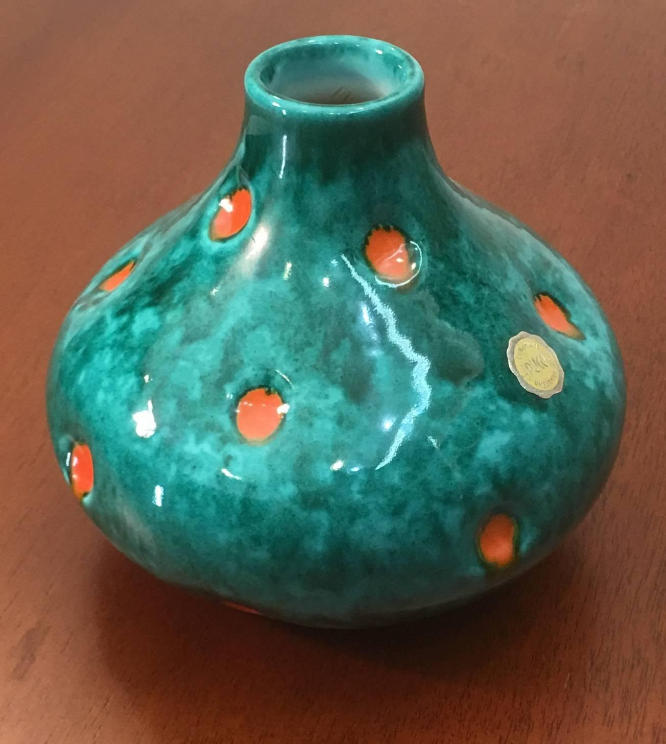 Featuring a polka dot pattern of orange dots over a mixed sea green glaze, this pair of hand-thrown ceramic vases by Pucci affords you the opportunity to own a matched pair from the studio of the company; which is an uncommon offering.

Price is