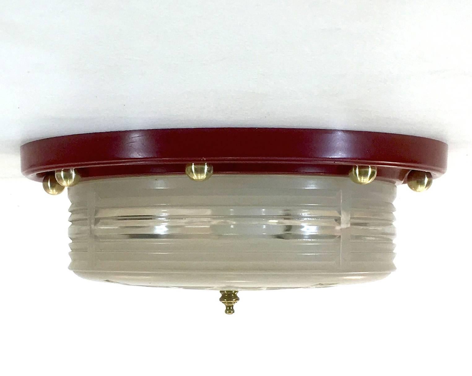 Produced by Lightolier, circa 1940, this flush mount ceiling lamp features glass with etched nautical compass points with the flush mount having eight solid brass spheres to match.

Measures 12" in diameter and has a total drop of 4.75",