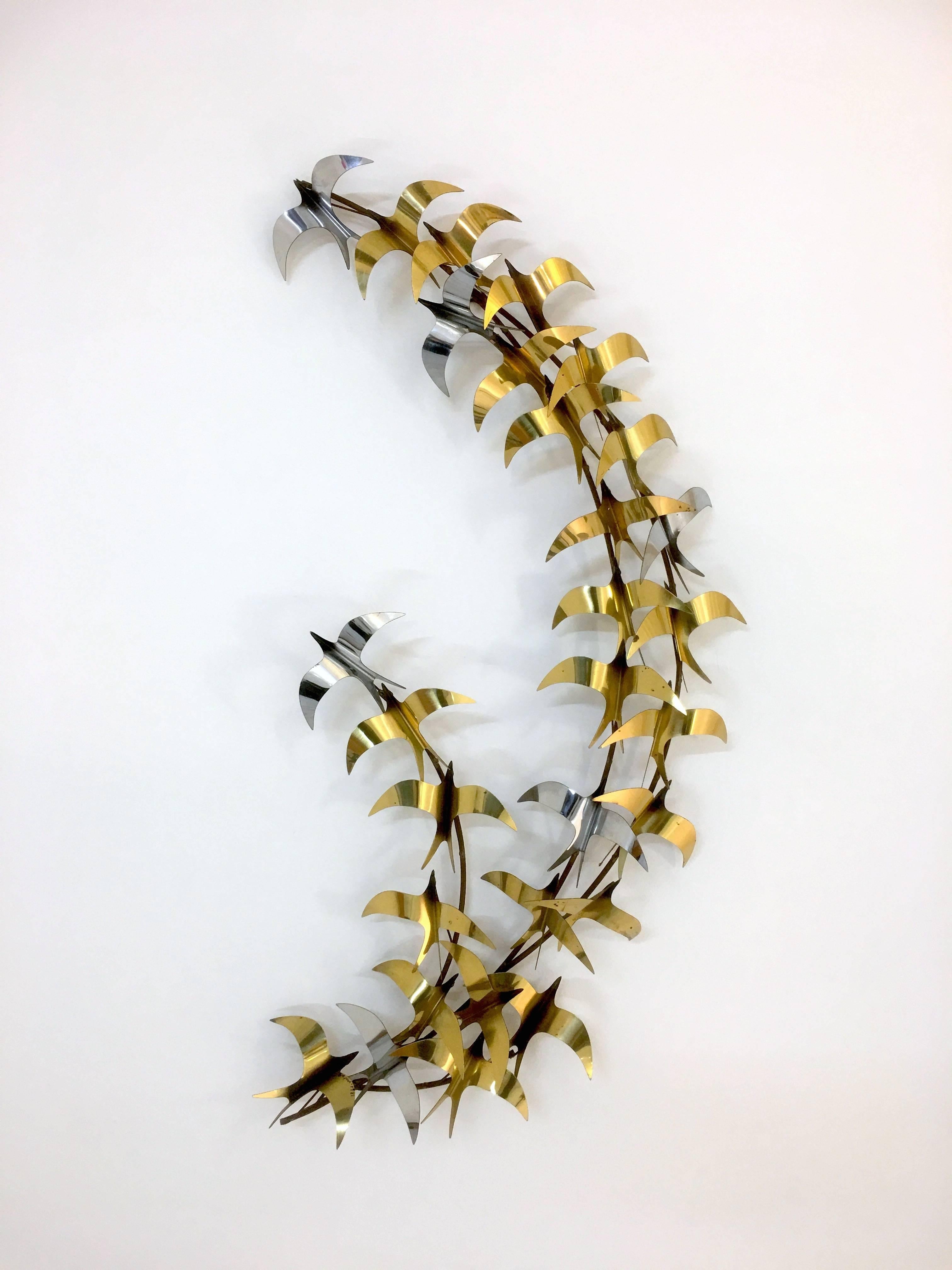 Curtis Jere
1981
Flock of birds
45 wide x 22 inches tall.

A large wall sculpture of birds in brass and chrome signed by Curtis Jere, 1981. Because it is raised, light will cast shadows of the birds onto the wall adding to the depth and feel of the