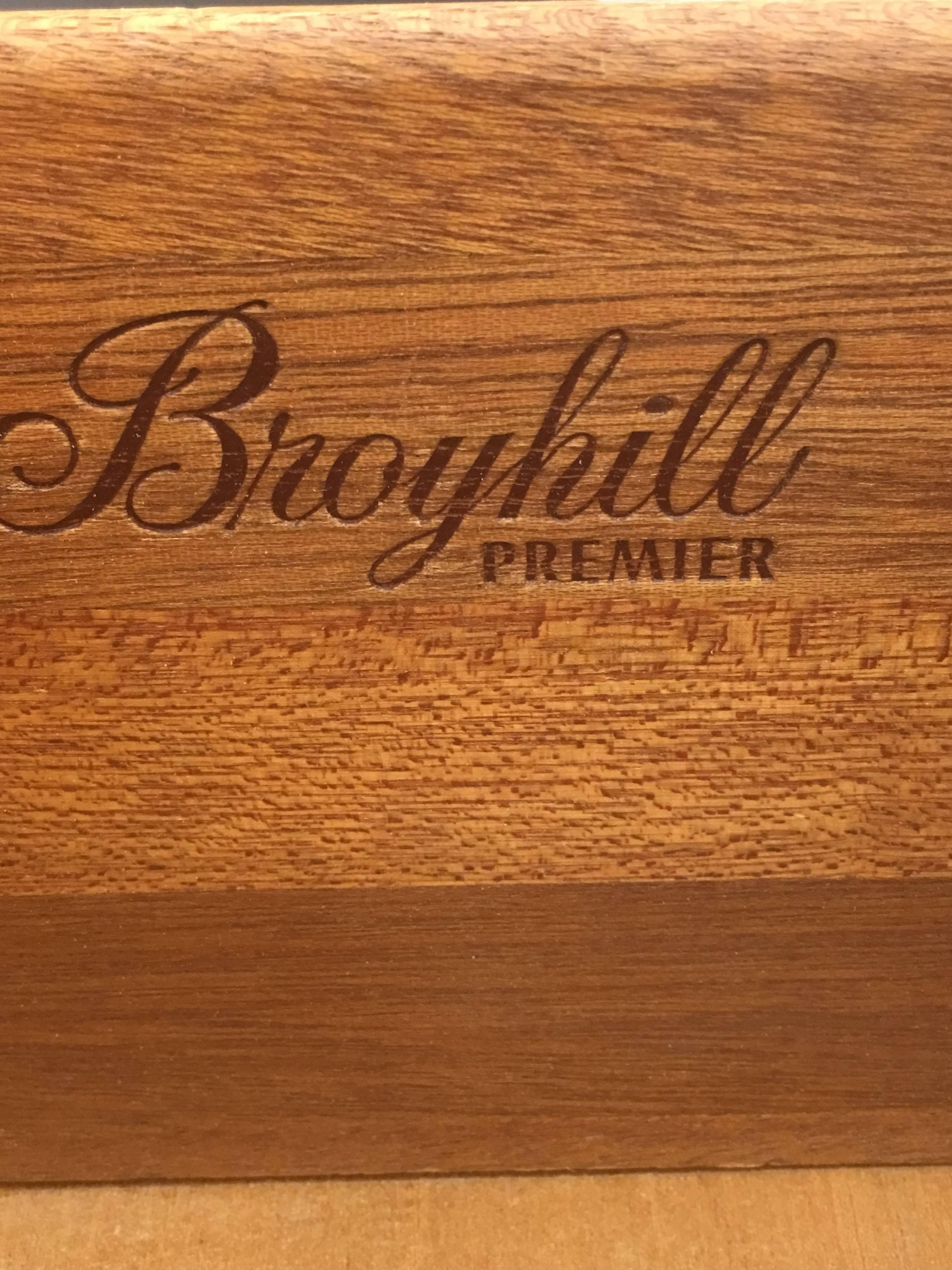 Produced in 1970 from Broyhill Premier, this uncommon low boy and mirror has a matching nightstand and also a double headboard if required. This dresser is produced to uncompromising standards featuring steel drawer slides, solid steel handles with