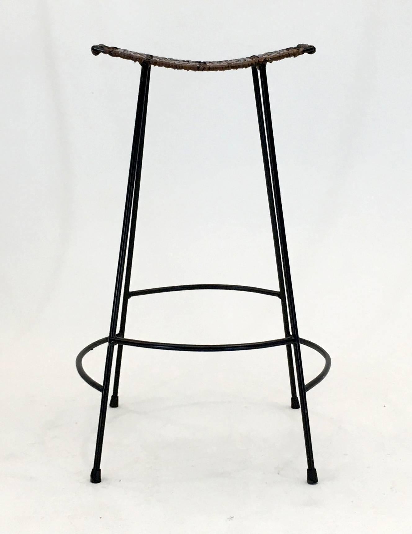 Attributed to Arthur Umanoff for Raymor, these three tiki style bar stools feature woven wicker cane in two tone. The cane is in good condition with minimal signs of use and the frames are in excellent condition with all rubber feet