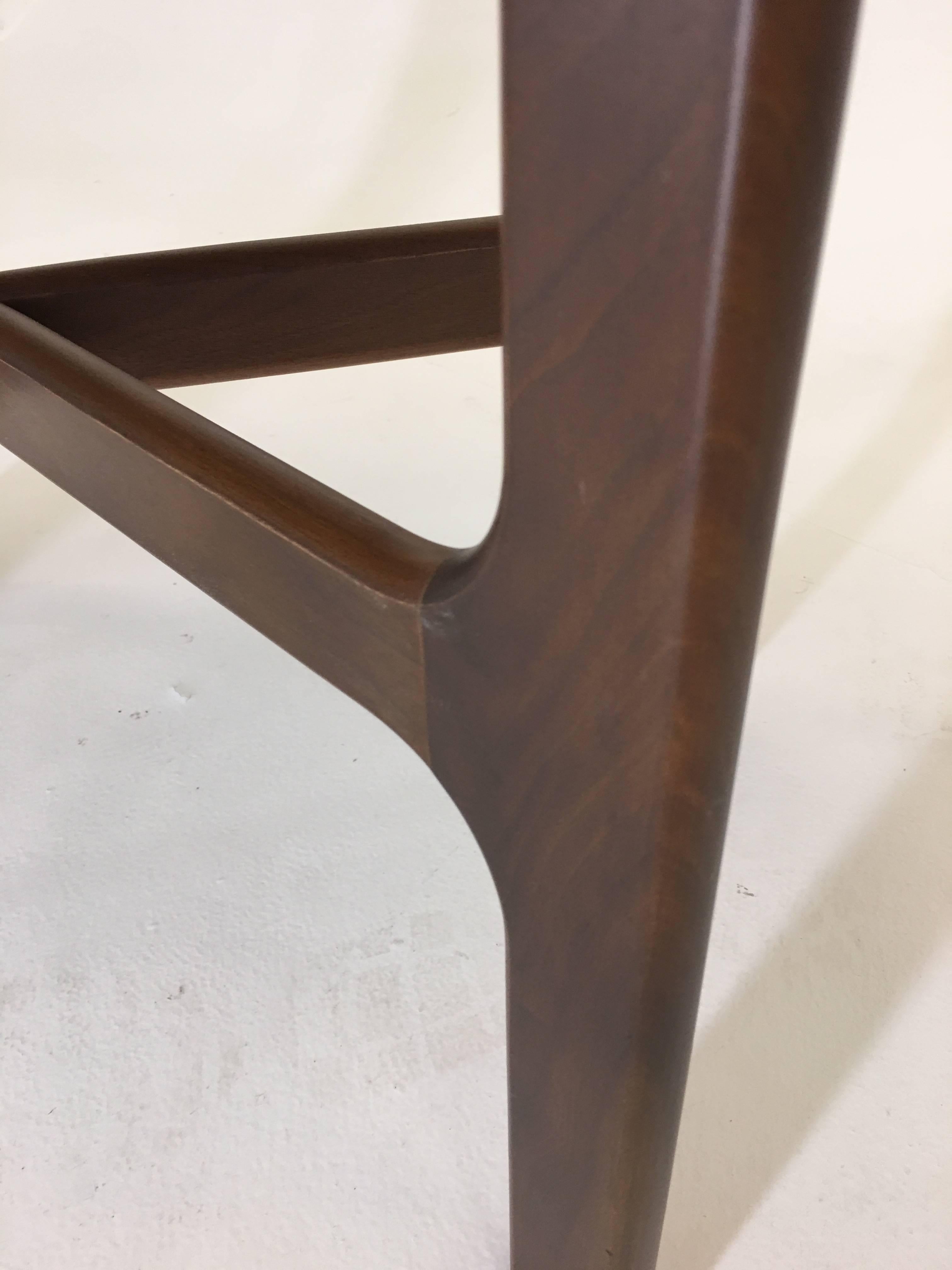 Unsigned though likely the work of Dunbar or Selig, this occasional table stands out from the rest through the fine use of walnut and black lacquer in a classic Danish Modern style. The black surface of the top being framed with walnut gives the