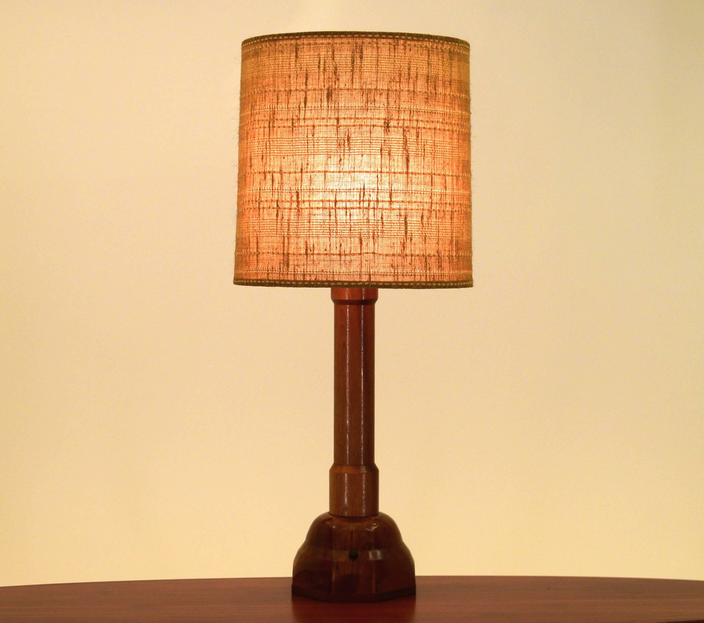 This table lamp was custom-made by cabinet maker R G Busby for a client in 1973, it is one of a kind and unique. It has a very large hexagonal base that supports a solid column much like a balustrade. The base is comprised of blocks of walnut and