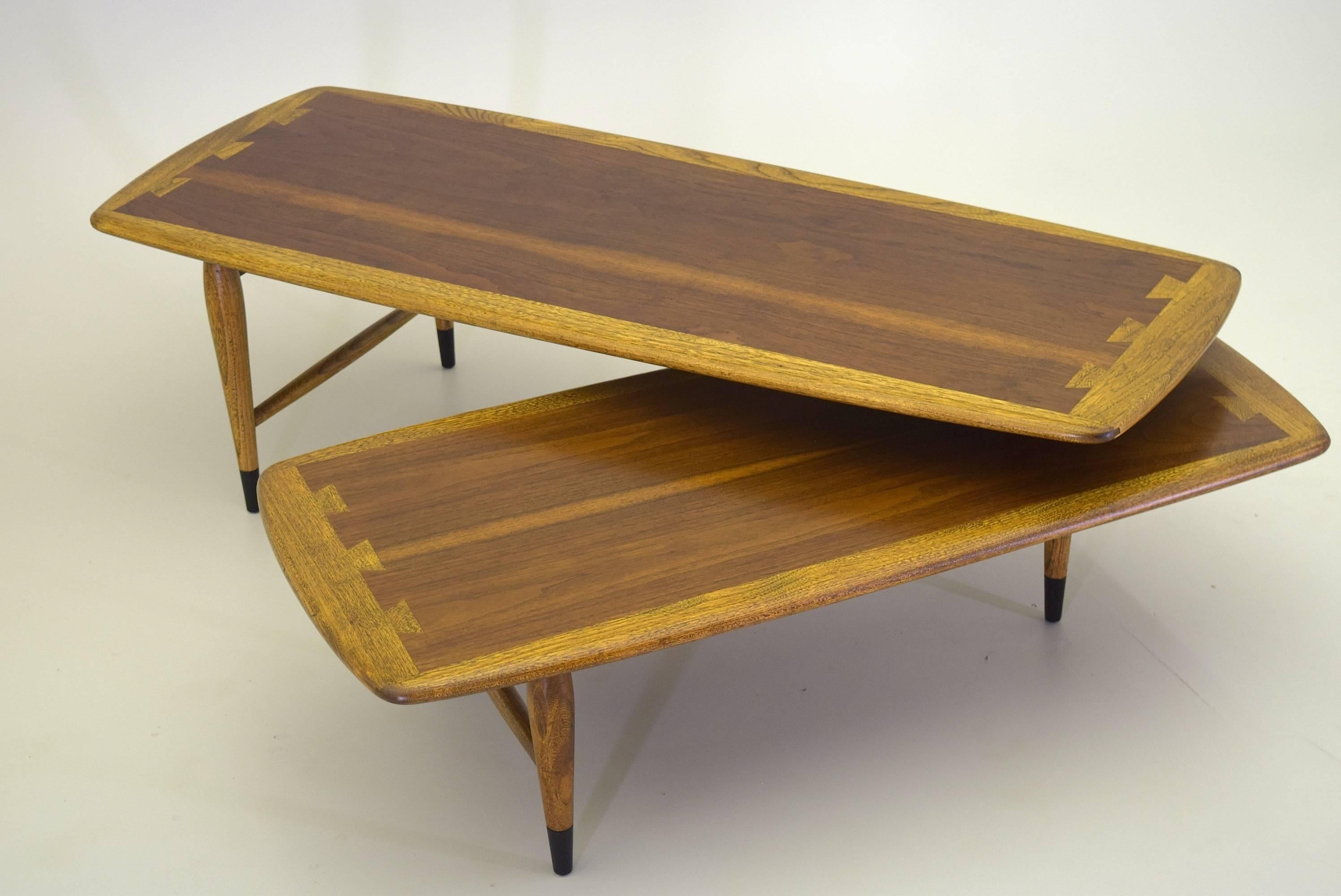 This articulating coffee table (referred to as the Switchblade Table) was part of the Acclaim design line by Andre Bus for Lane Furniture introduced in 1958. 

This exceptional vintage table has been fully restored, completed in a fine lacquer and