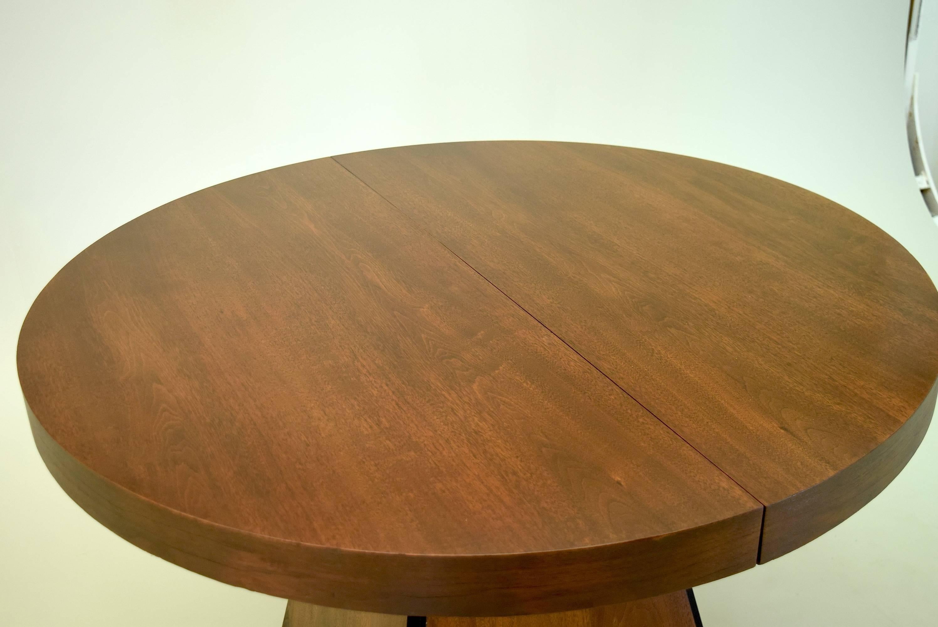 Designed by modern design legend Pierre Cardin and produced by Dillingham Furniture, this striking obelisk base dining table is one of the few known examples produced entirely in walnut. 

The table seats four, and with the extension leaf in use
