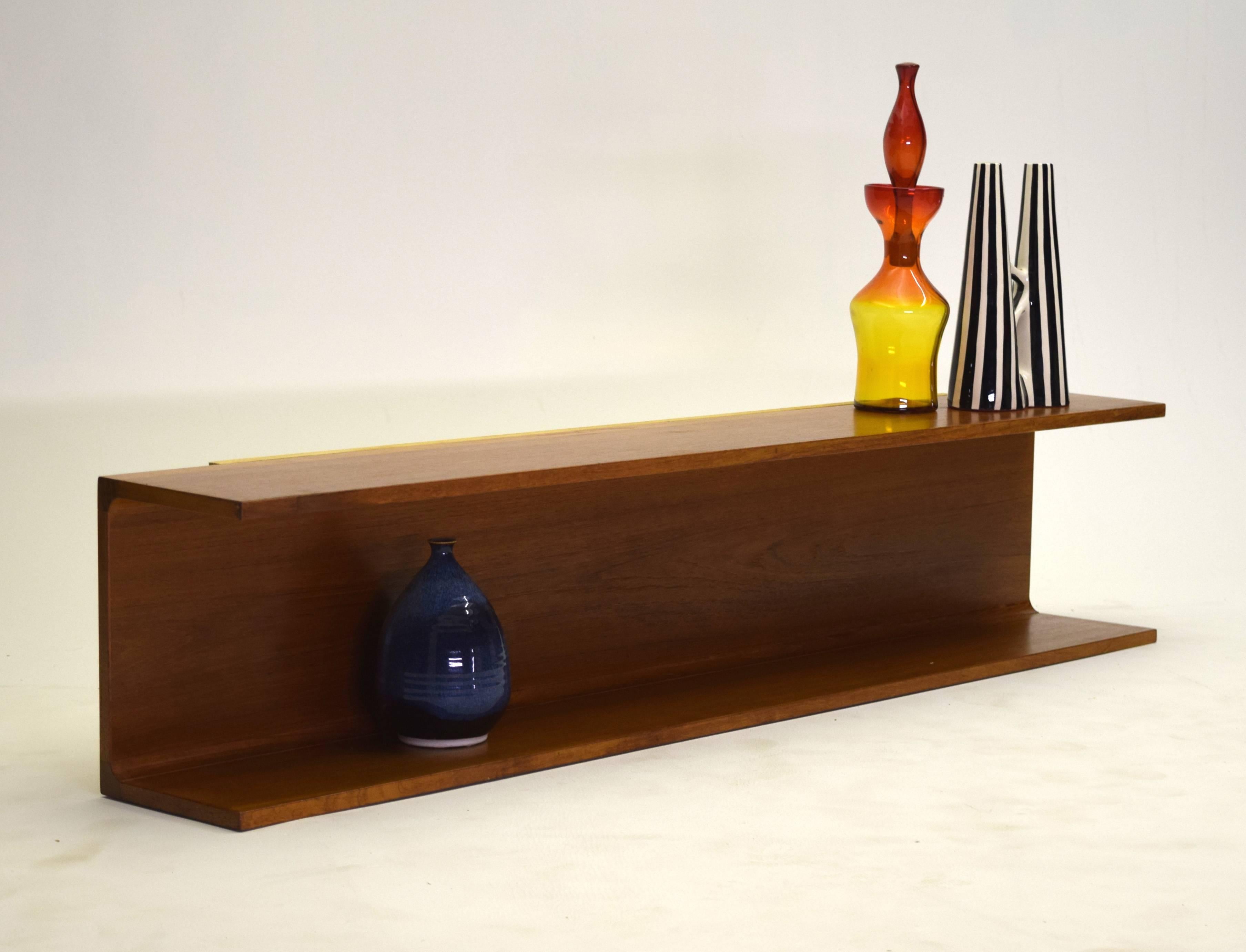This signed shelf is produced from teak and measures 55