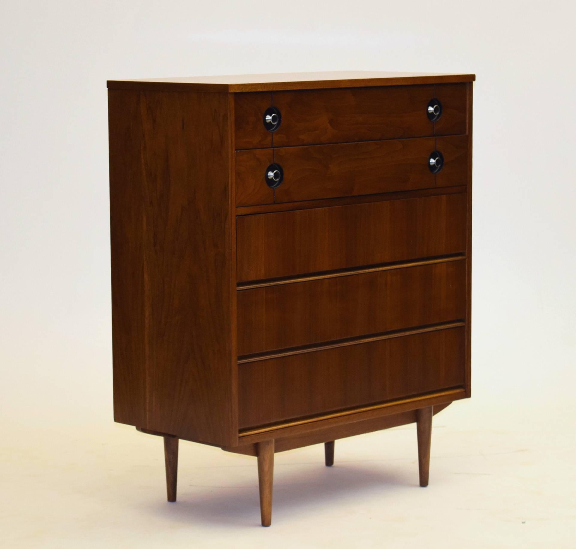 Pierre Debs for Distinctive Furniture by Stanley.

Nightstand, dresser and highboy are all inclusive of this offering. Precision sculpted walnut and uniform woods coupled with unique pulls make this vintage suite produced around 1960 ideal - and