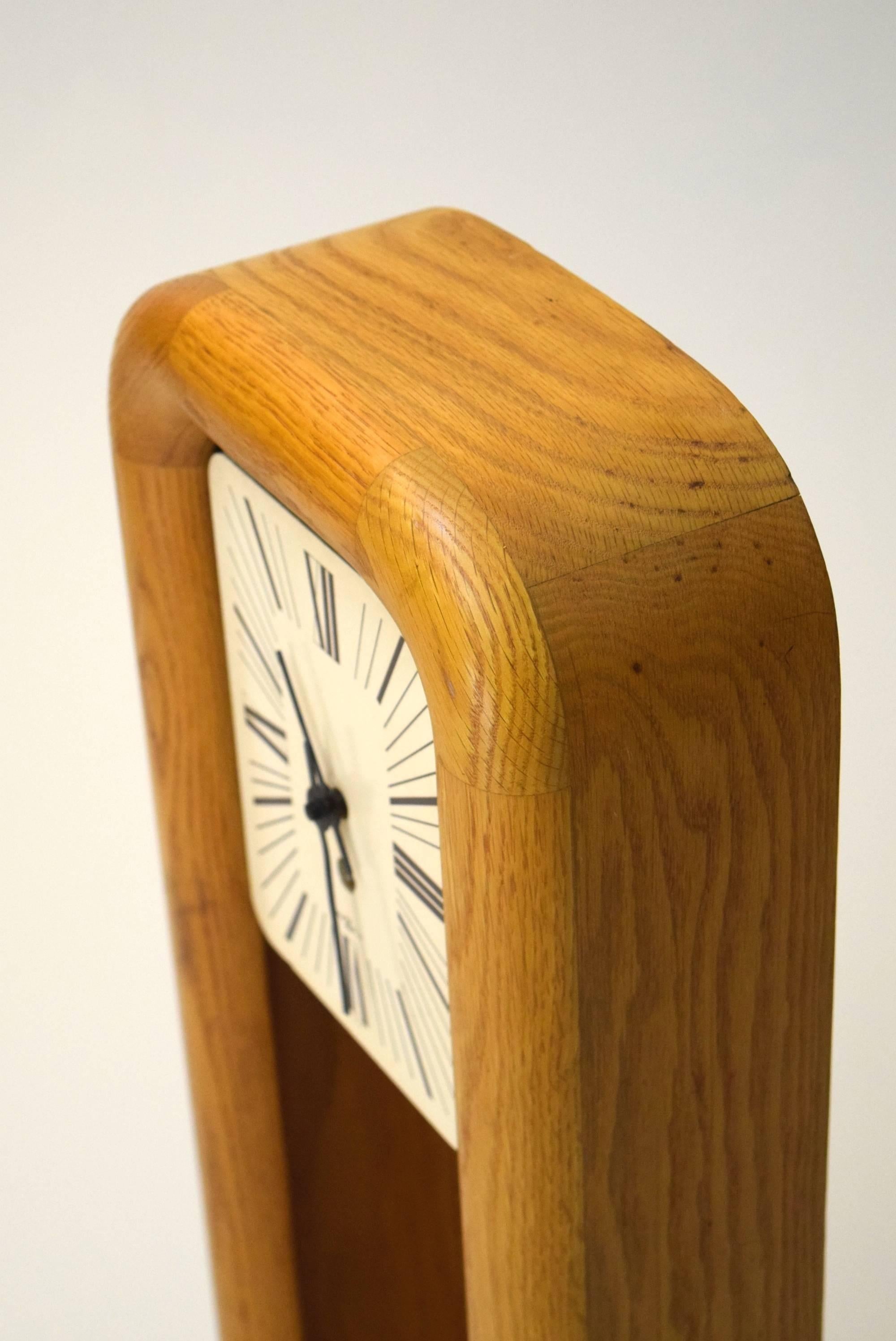 
Clock by Howard Miller with design by Arthur Umanoff.

A heavy grandfather style wall hanging clock produced of solid oak and is 
operated by a key. All original. It can also be used as a mantel clock. 
This clock measures 34