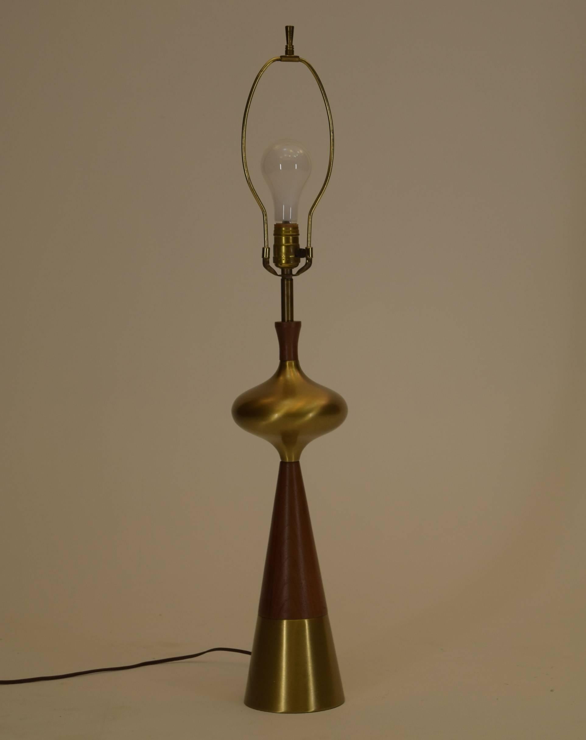 Featuring sculpted walnut coupled with solid brass components, this singular lamp by Tony Paul is a masterpiece in danish design with American thought.

Produced in 1955 and all original this lamp is in excellent condition.

The lamp shade is