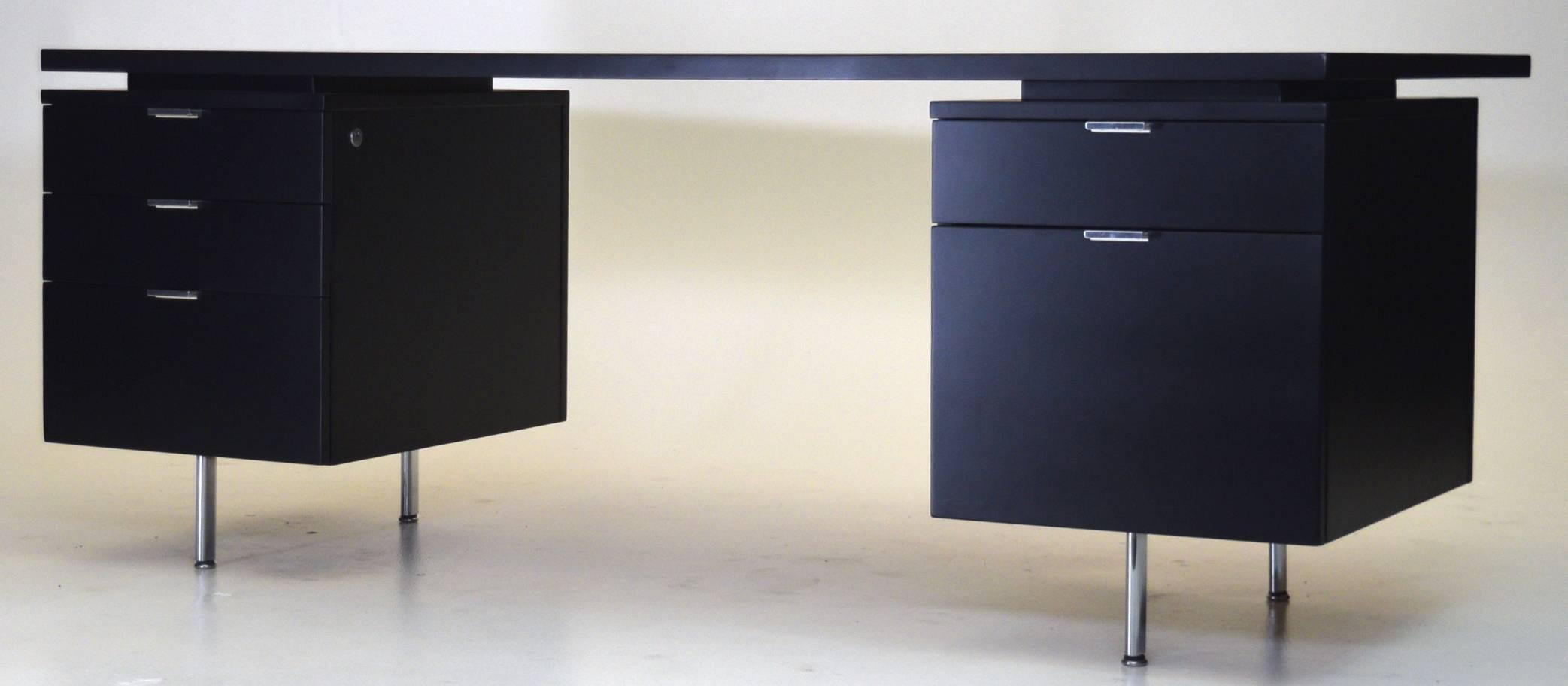 Bold in appearance and newly refinished, this uncommon floating desk was designed by George Nelson for Herman Miller, circa 1950. Chrome legs and pulls, with the desk top floating upon plinths, this vintage desk makes a bold statement measuring