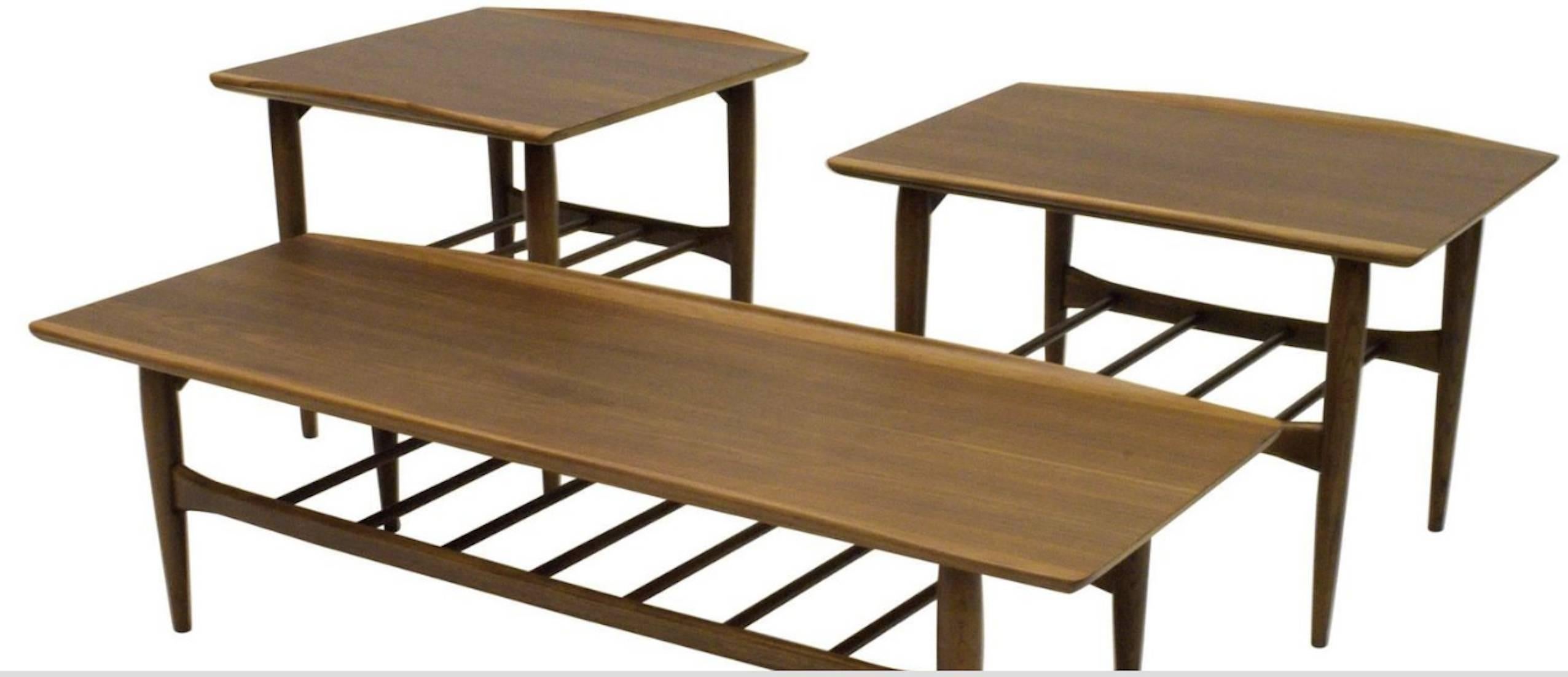 We have three available from the series tables in walnut, all with solid surfboard stylized edges and magazine rack shelfs. Each two tier table is different in measures but all feature a magazine rack shelf as well raised edges typical of Danish