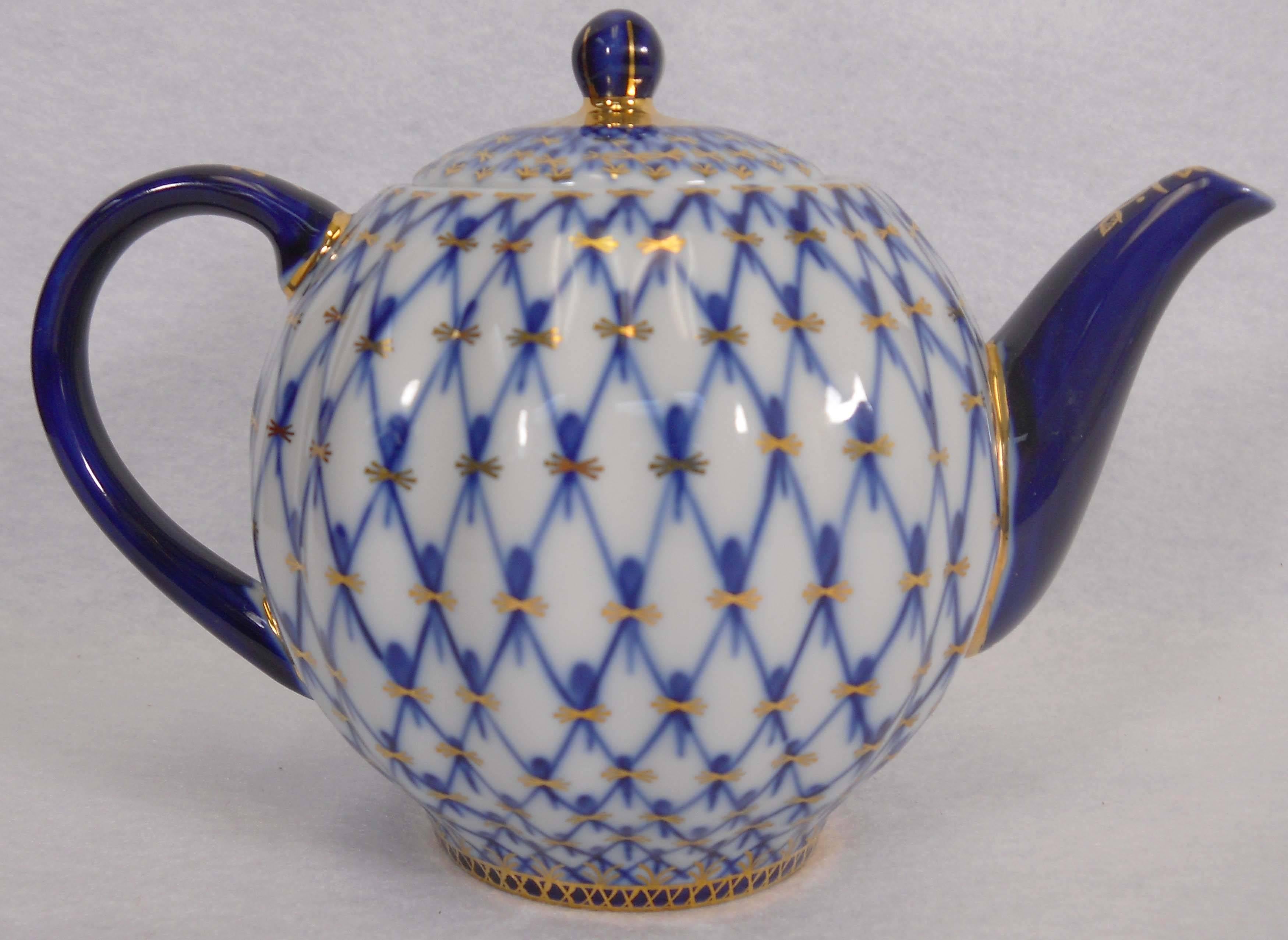  Beautifully hand painted cobalt blue “net” design embellished with at 18-karat gold. This teapot was made in the imperial Russian porcelain factory in St. Petersburg. The teapot measures 4 inches table to spout, and 5 inches at the widest point.