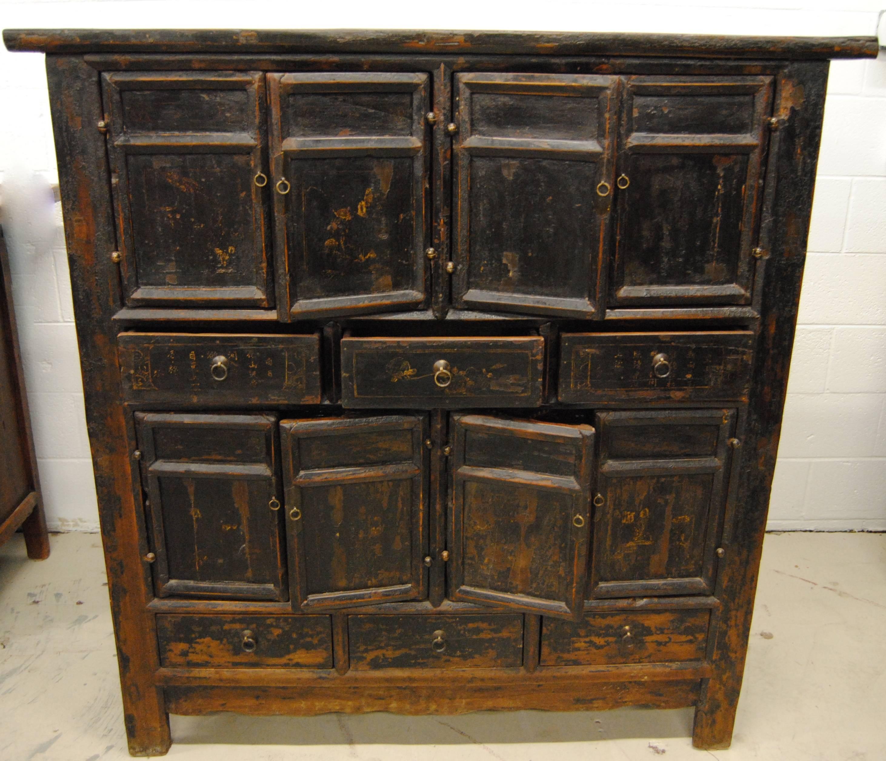 Antique Chinese six-drawer, four-bay elmwood armoire with lower scalloped apron. The Asian cabinet has all original lacquer with remnants of gold decorative calligraphy and figural that are just barely visible on the front panels of drawers and