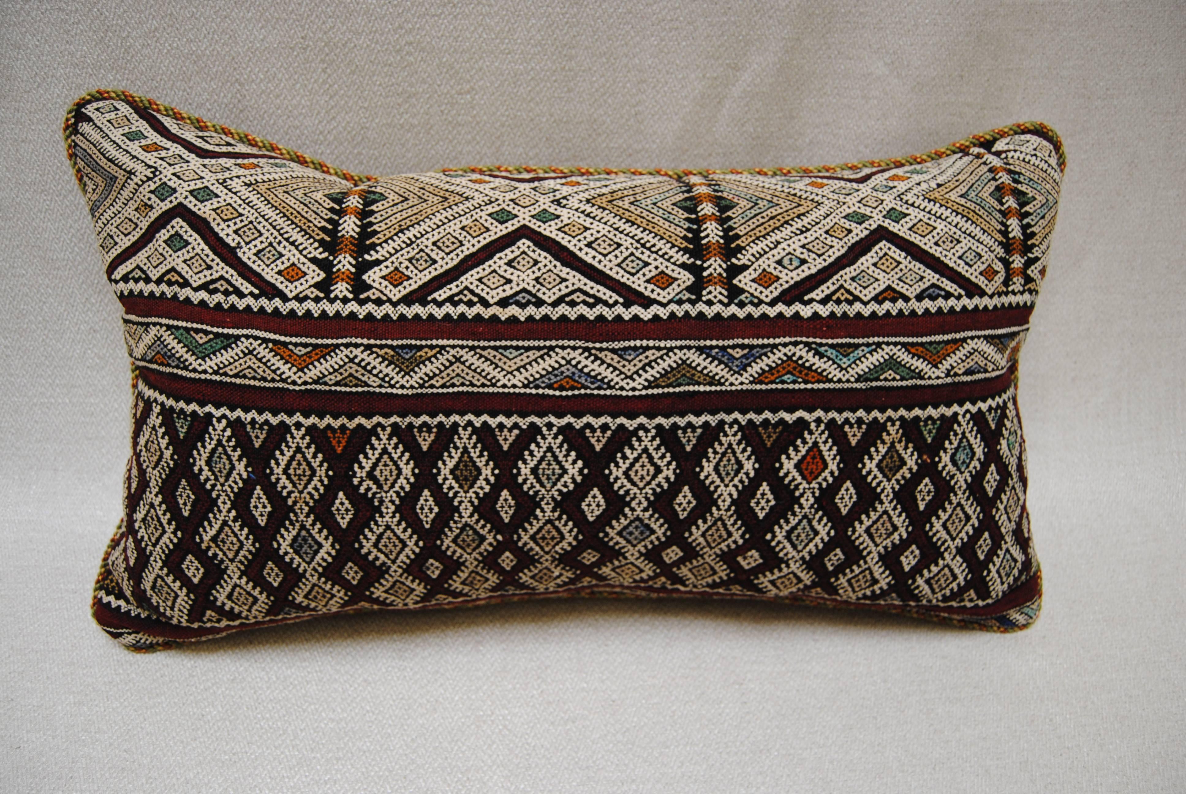 Custom pillow cut from a vintage hand-loomed wool Moroccan Berber rug from the Atlas Mountains. Soft, lustrous wool with all natural dyes, amazing colors. Very intricate weaving on this older piece. Pillow is corded with a Brunschwig trim and backed