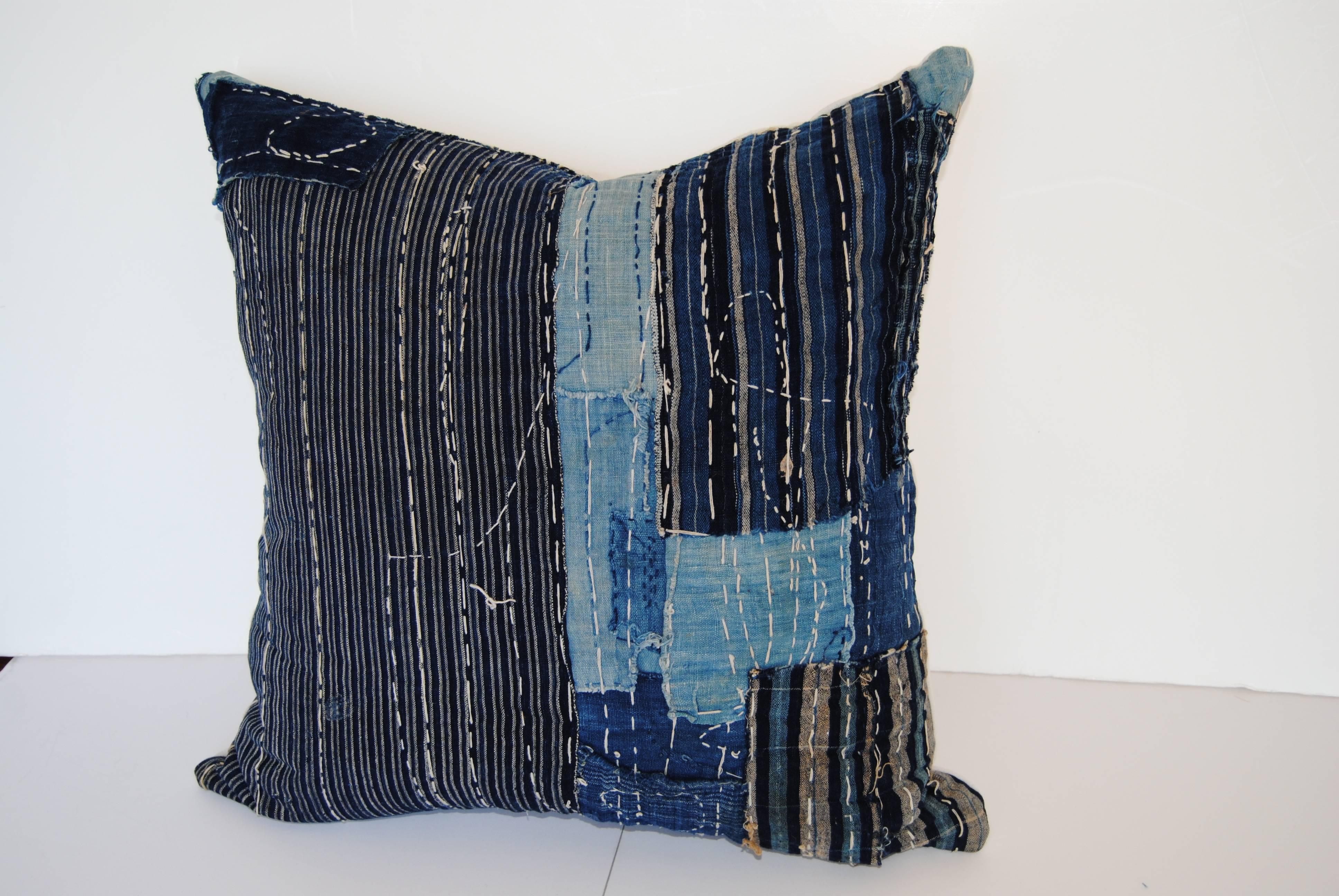 Custom pillow cut from an antique Japanese boro futon cover. The boro, meaning rags, has hand loomed cotton indigo textiles from the late 1800s to early 1900s. In some places there are up to six layers of fabric to cover the wear, all held together