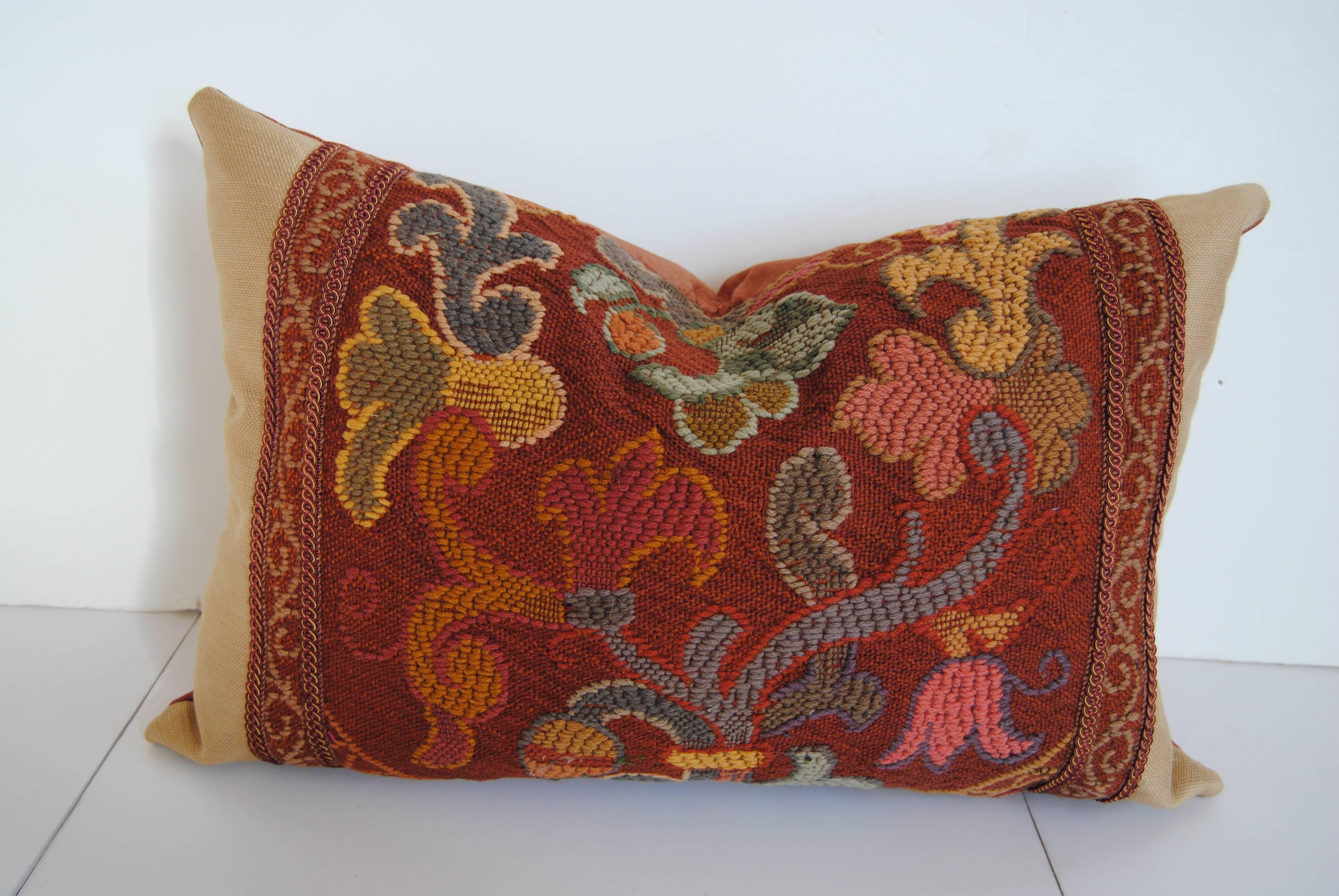 Custom pillow cut from a French woolwork tapestry. Made in Paris, circa late 1800s. Fragment is edged with an imported gimp and faced with a cream silk. Pillow is backed in a paprika silk, filled with an insert of 100% down and hand-sewn closed.