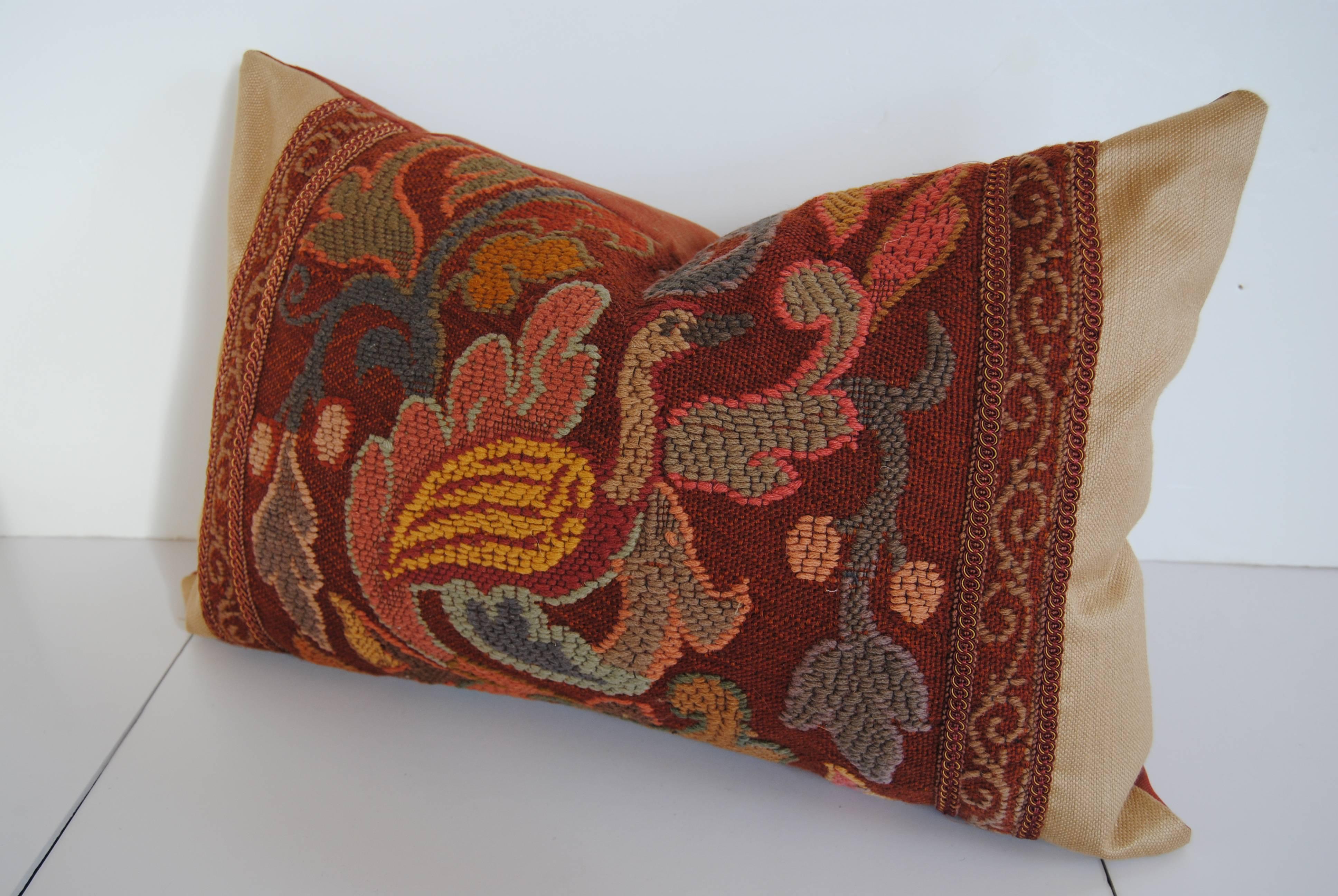 Custom pillow cut from an antique French hand loomed woolwork tapestry that was made in Paris. The fragment is edged with an imported gimp and faced with cream silk. The pillow is backed in paprika silk, filled with a 100% down insert and hand-sewn