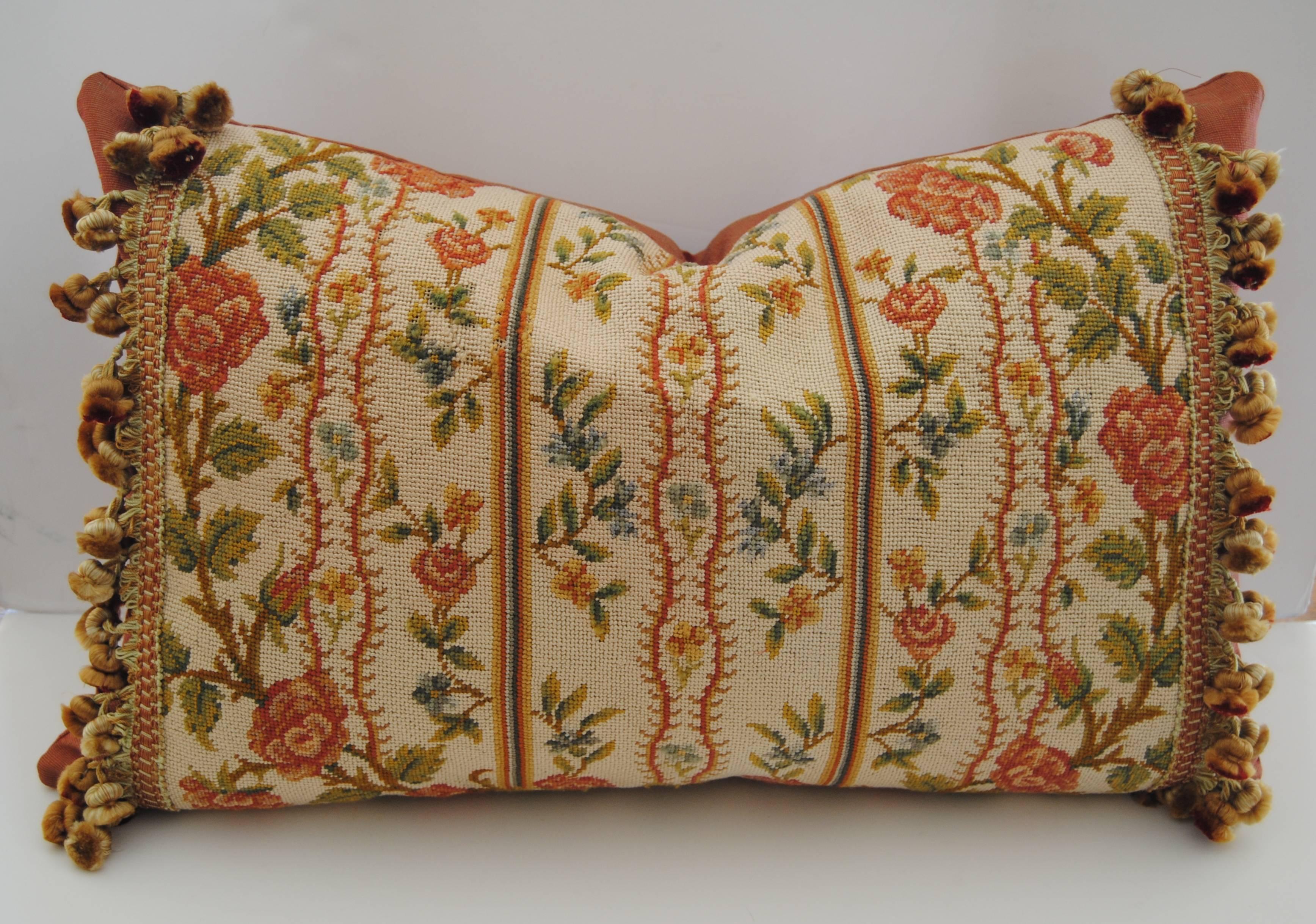 Custom pillow cut from an antique French needlepoint fragment from late 1800s. Hand worked in silk and wool with good color. Minor thread loss, shown in photo but not detracting from the design. Pillow is edged with Scalamandre silk tassel trim and