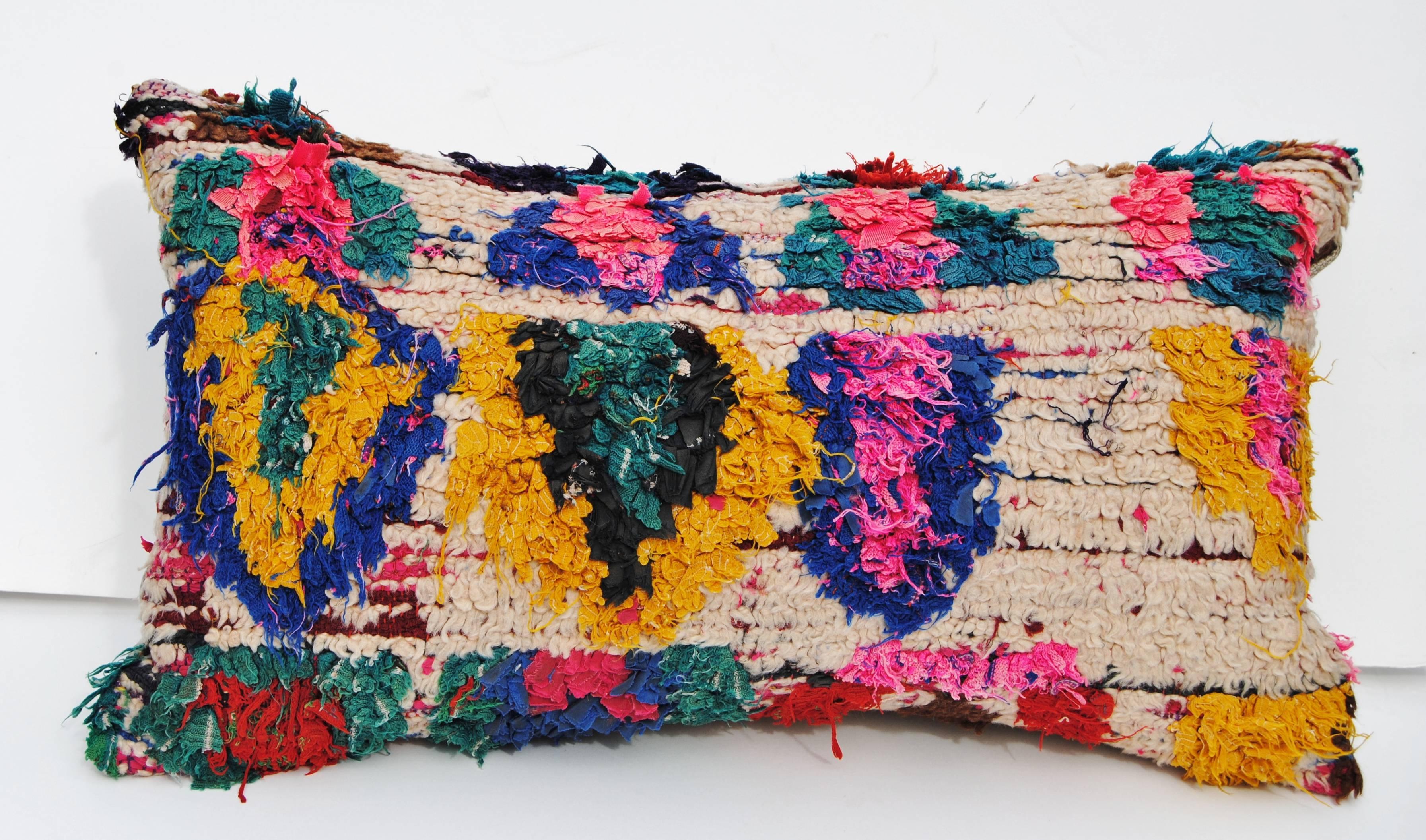 Custom pillow cut from a vintage hand loomed wool Moroccan rug from the Atlas Mountains. Flat-weave cream wool is embellished with tufted tribal designs in vivid color. Pillow is backed in linen, filled with an insert of 100% down and hand-sewn
