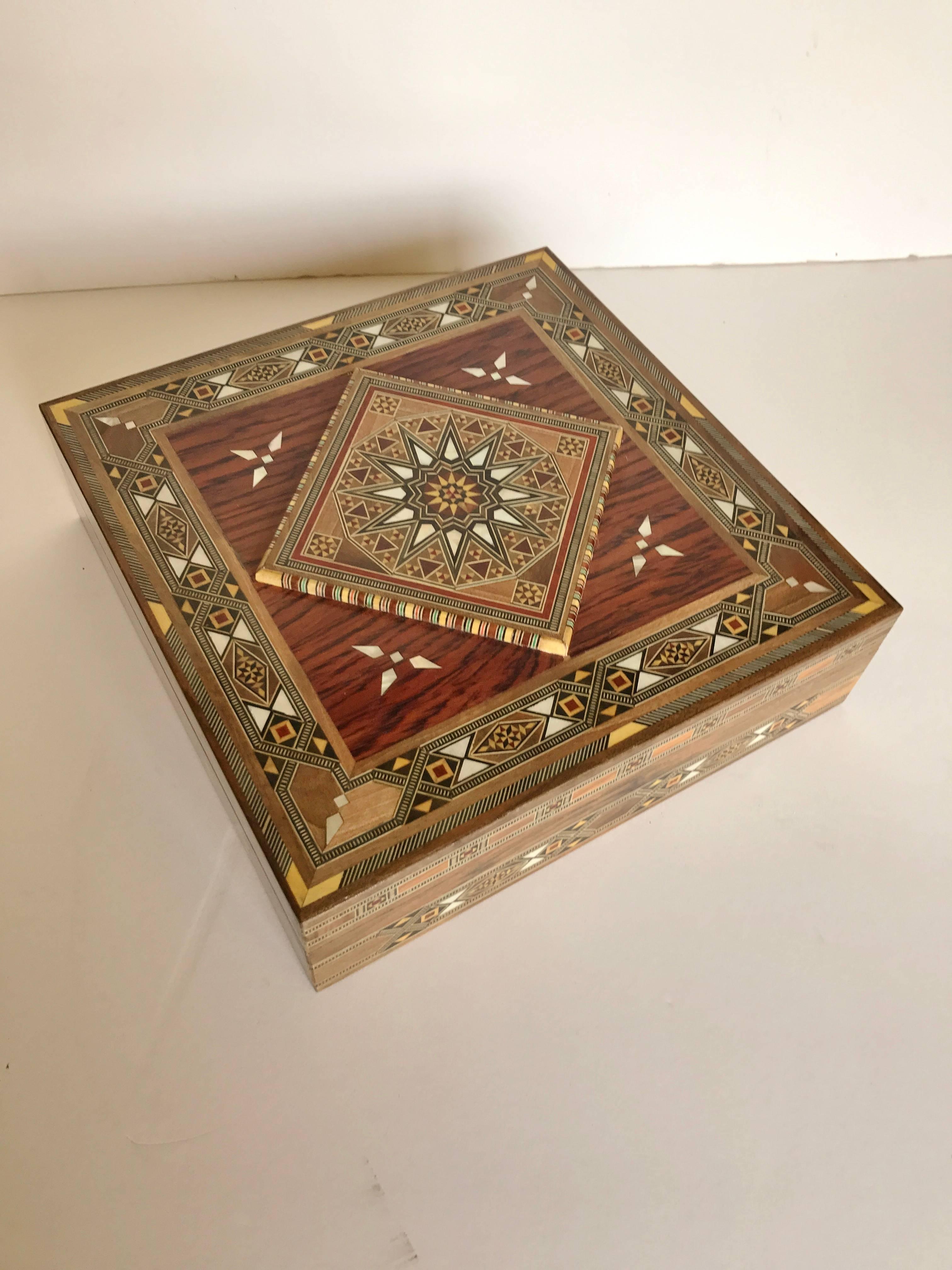 Syrian walnut wood box with fruitwoods and mother-of-pearl. The box has a raised center diamond design with very intricated inlay. It is lined in a cream leather. Handmade by skilled Syrian craftsmen from Damascus. In new condition, several