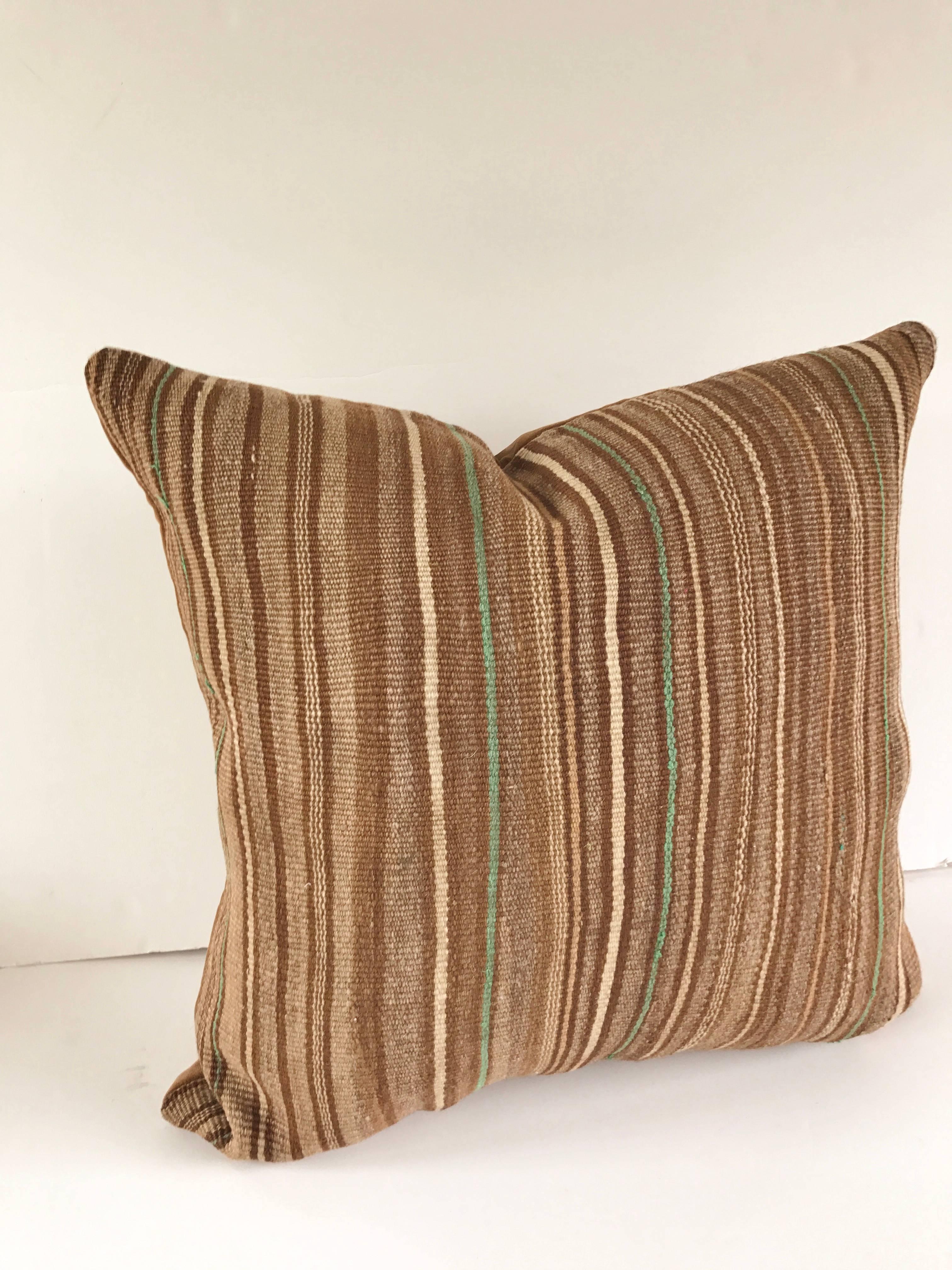 Custom pillow cut from a vintage hand-loomed wool Moroccan Berber blanket or rug from the Atlas Mountains. Wool is soft and lustrous win natural color. Pillow is backed in a nut meg brown velvet, filled with an insert of 50/50 down and feathers and