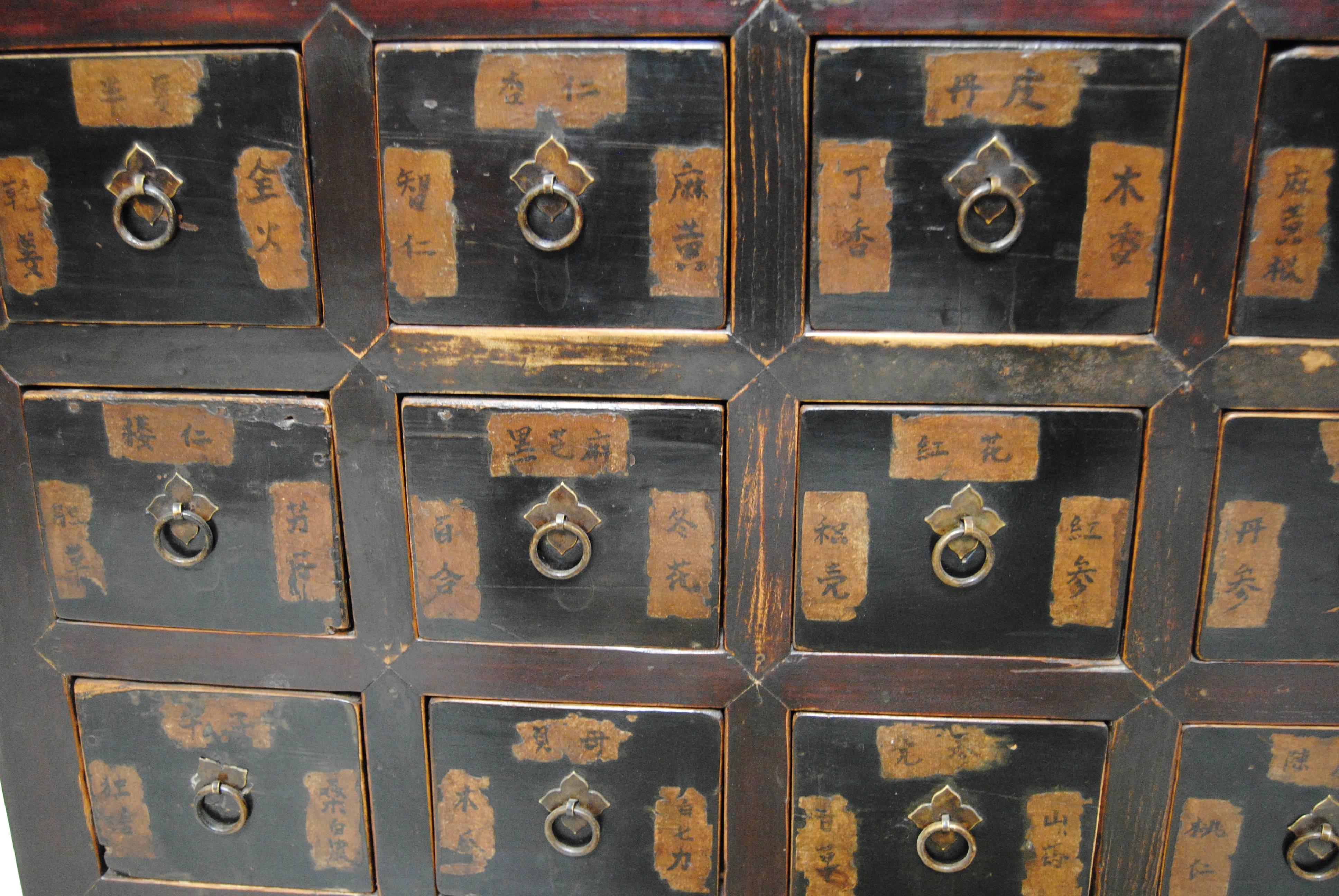 Very rare antique elmwood Chinese apothecary cabinet with two display shelves and 15 drawers. Very good pierce carved apron on lower panel of cabinet. The apothecary has sectioned drawers on the lower half that originally stored medicinal herbs. All